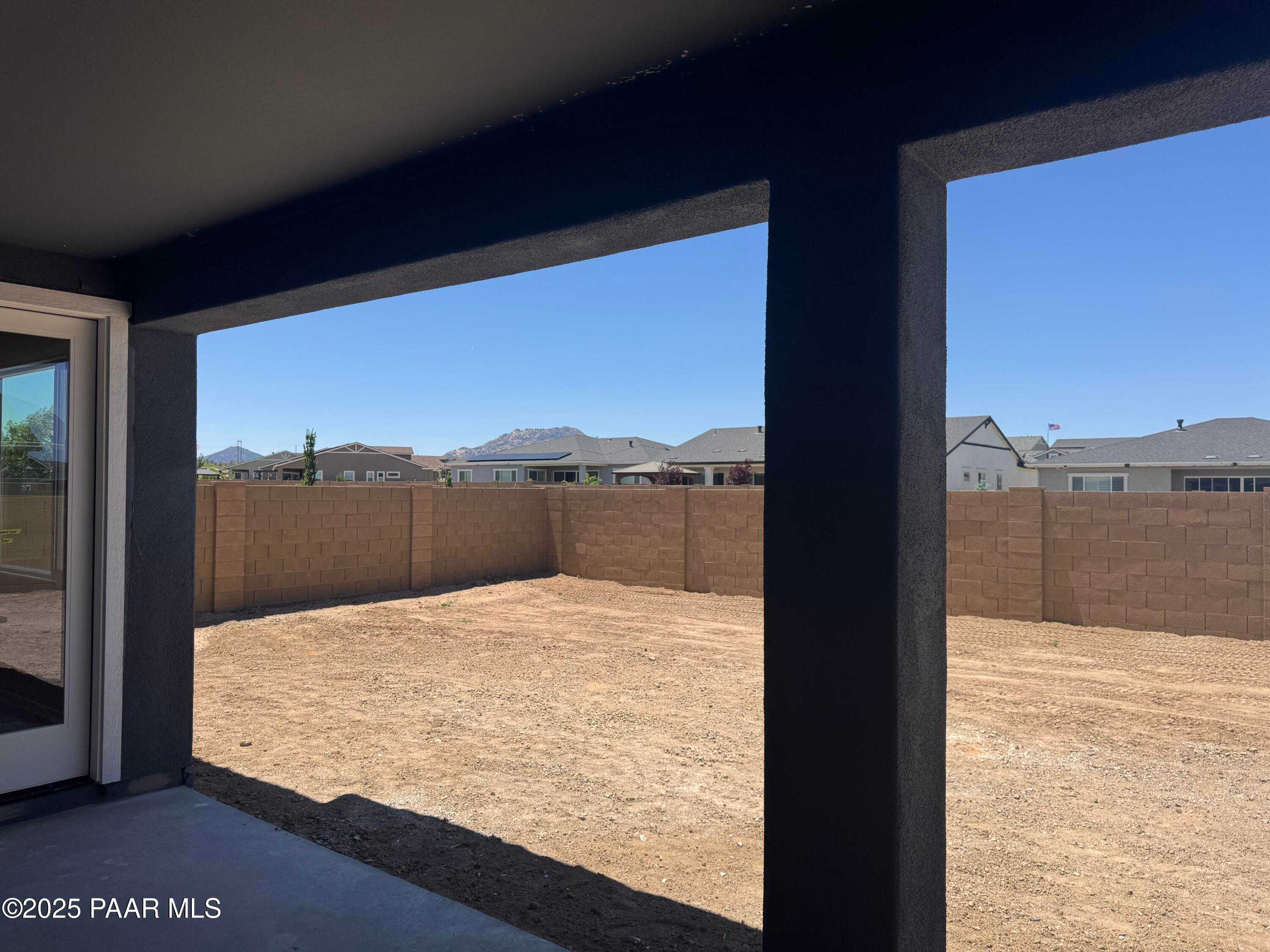 Expansive backyard with block fence viewed through sliding glass doors in Davidson Homes The Durango II A, Prescott, Arizona