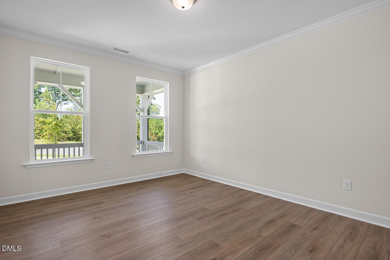 Bright bedroom with wood-style flooring and large windows in The Hickory II B floor plan by Davidson Homes in Montrose.