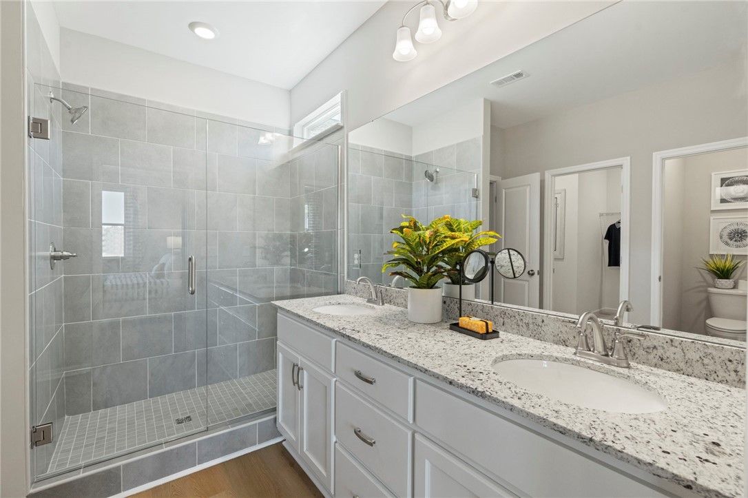 Modern master bath with frameless glass shower, double quartz vanity, and subway tile in Davidson Homes Phoenix B, Opelika, AL