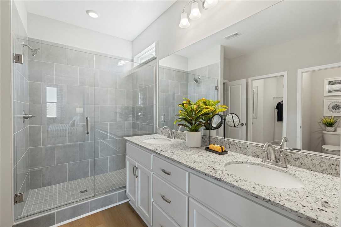 Modern master bath with frameless glass shower, double quartz vanity, and subway tile in Davidson Homes Phoenix B, Opelika, AL