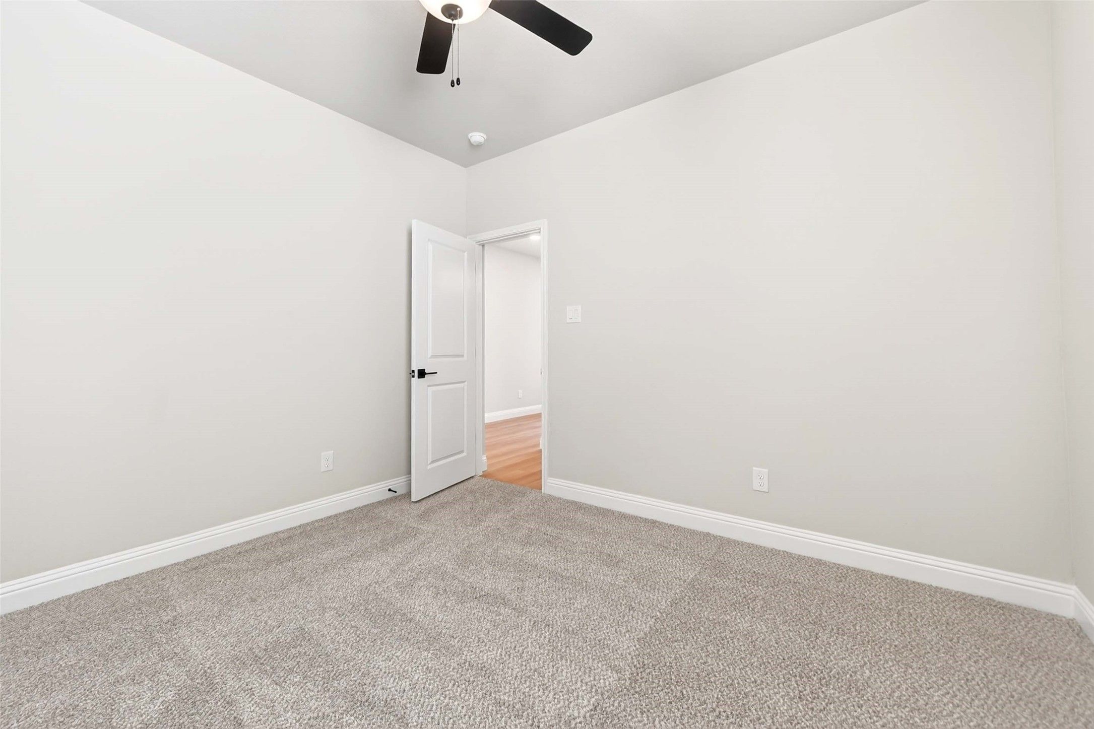 Spacious bedroom with plush carpeting and ceiling fan in The Holly C floor plan at Parks at Foster Crossing, Anna, Texas.