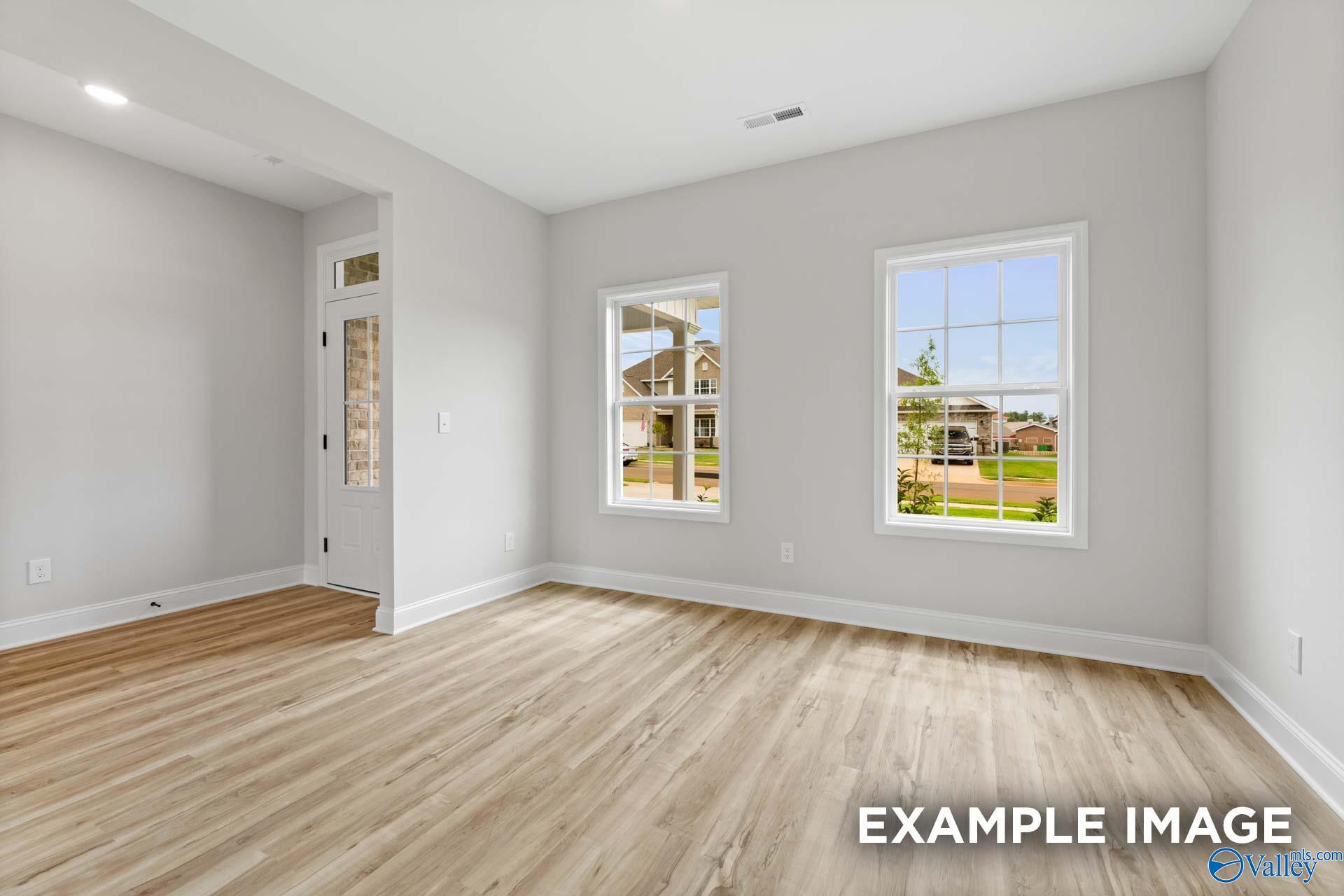 Bright, open-concept living area with wood-style flooring in The Shelby B floor plan at Jaguar Hills, Huntsville, Alabama.
