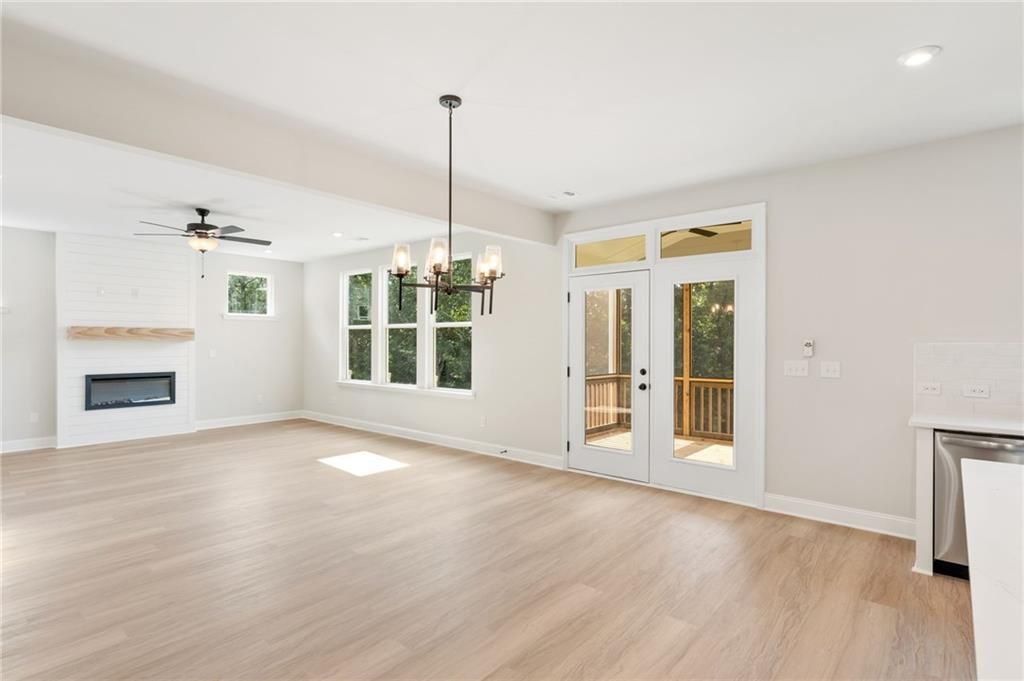 Bright living room with stone fireplace, French doors to deck, and hardwood floors in Davidson Homes The Hickory B, Buford, GA