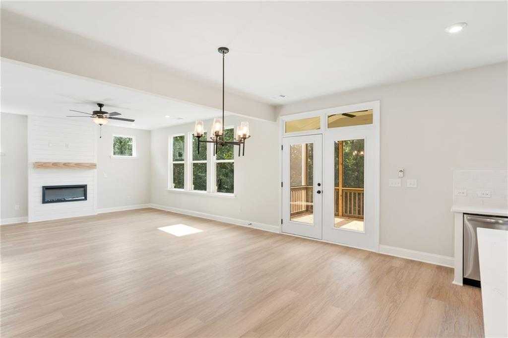 Bright living room with stone fireplace, French doors to deck, and hardwood floors in Davidson Homes The Hickory B, Buford, GA