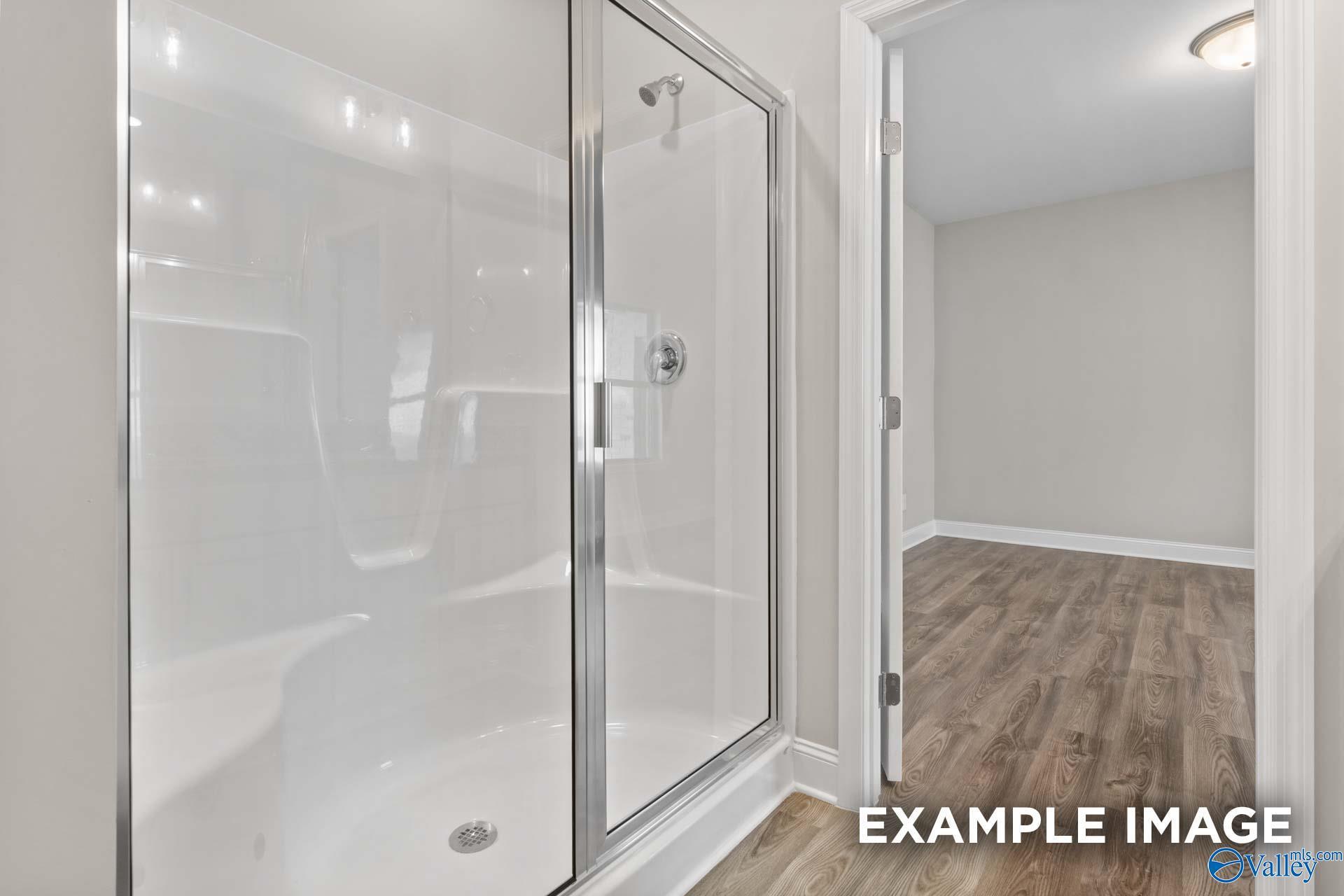 Modern frameless glass walk-in shower with white subway tile in The Camilla C 2-bedroom home, Hartselle, Alabama