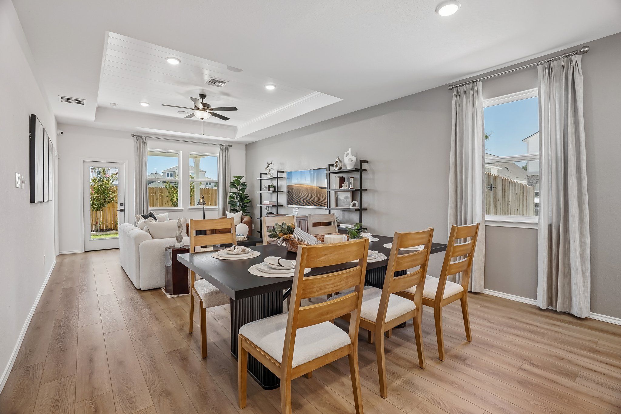 Open-concept dining and living area at Fairway Crossing in Converse, TX, featuring wood floors and Davidson Homes design.