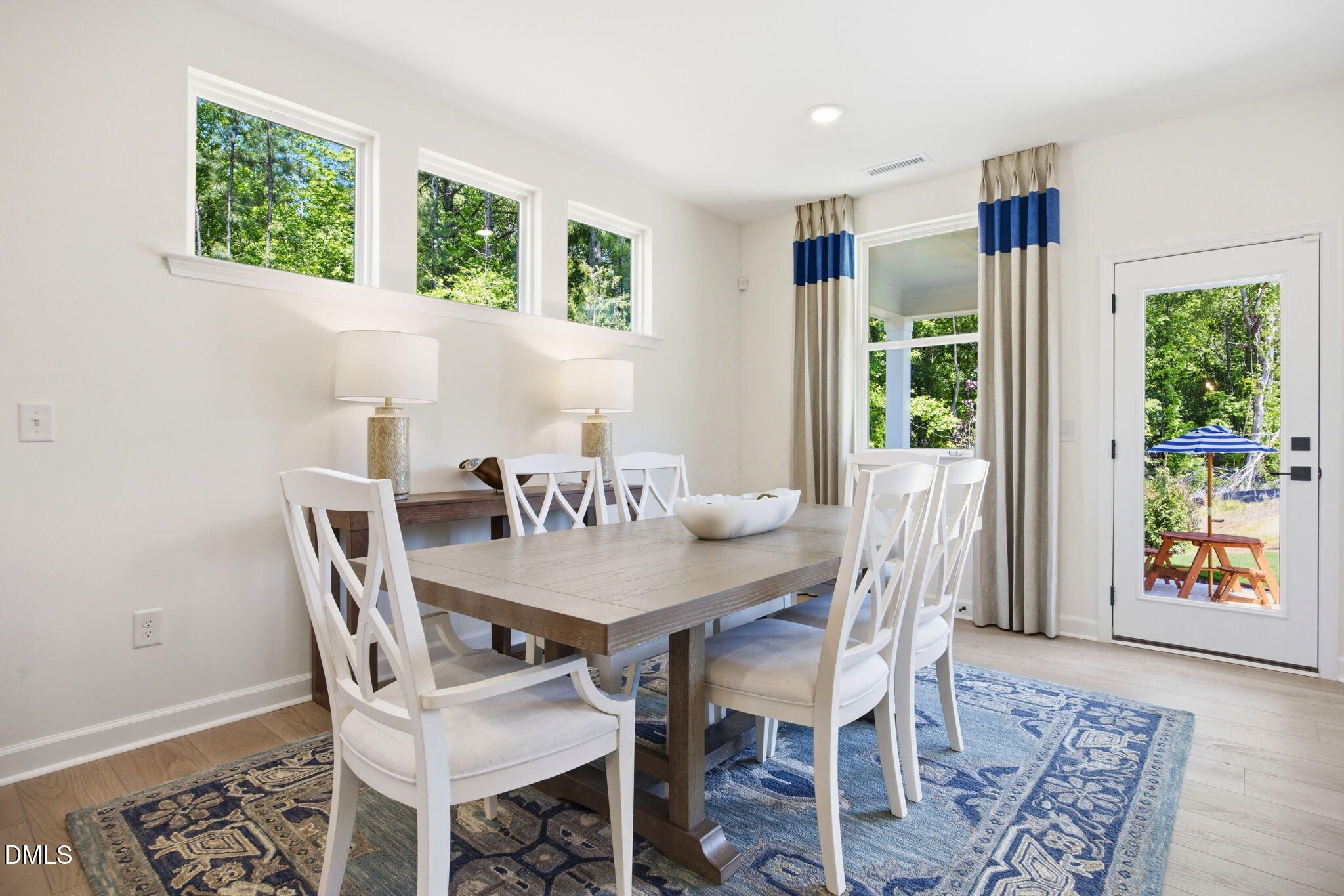 Bright dining area with wooden table and chairs in The Ashport M floor plan at Wendell Ridge, Wendell, North Carolina.