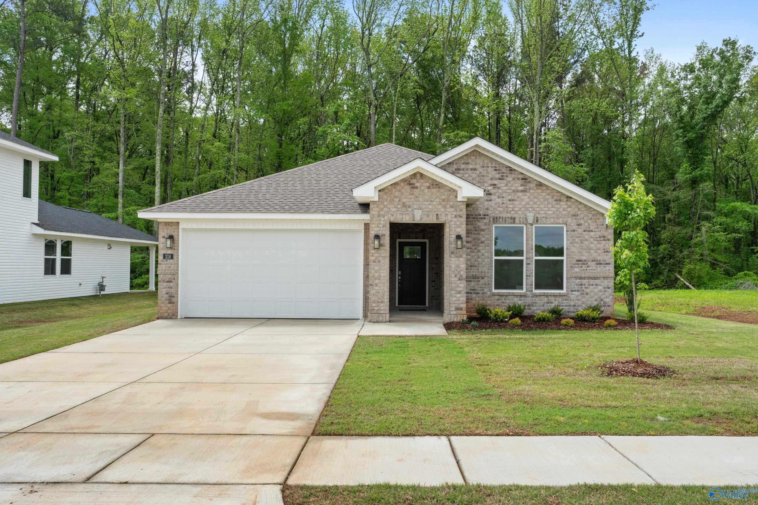 Modern 1-story brick ranch home with 2-car garage, driveway, and landscaped yard in Forest Glen, Hazel Green, Alabama - Davidson Homes The Luna