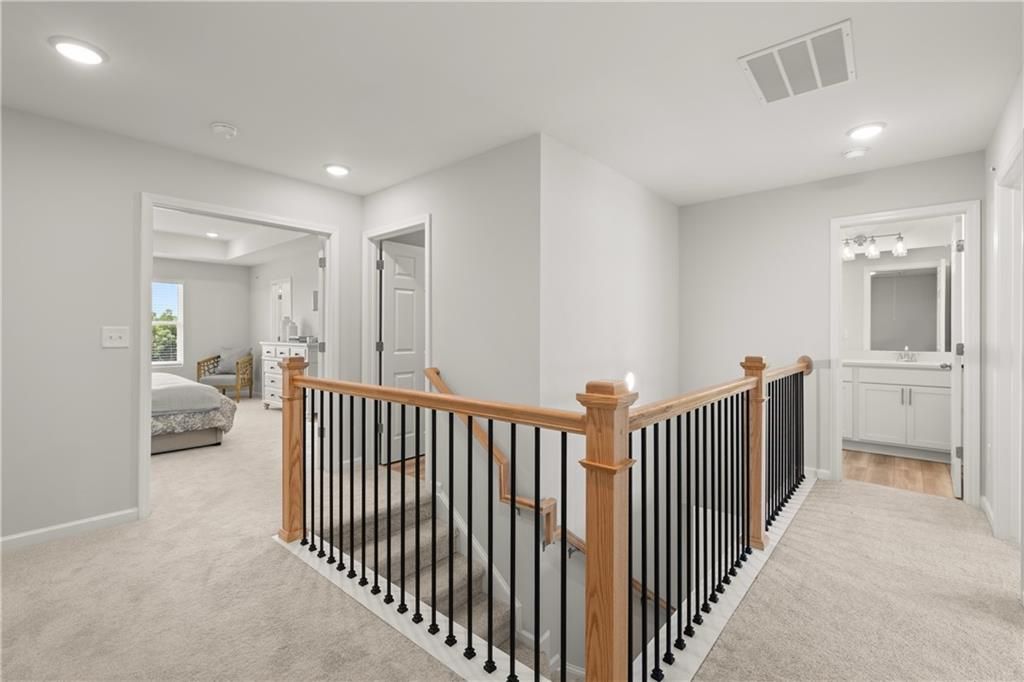 Upper landing with wooden railing and metal balusters in The Wake B floor plan at Hemingway, Cumming, Georgia.