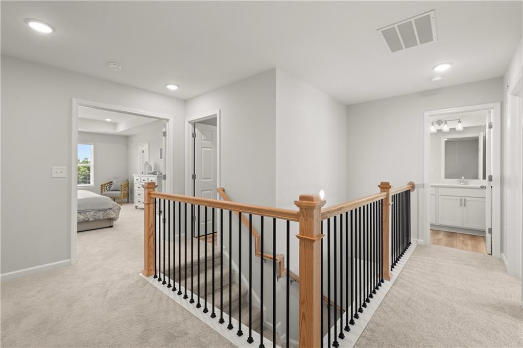 Upper landing with wooden railing and metal balusters in The Wake B floor plan at Hemingway, Cumming, Georgia.