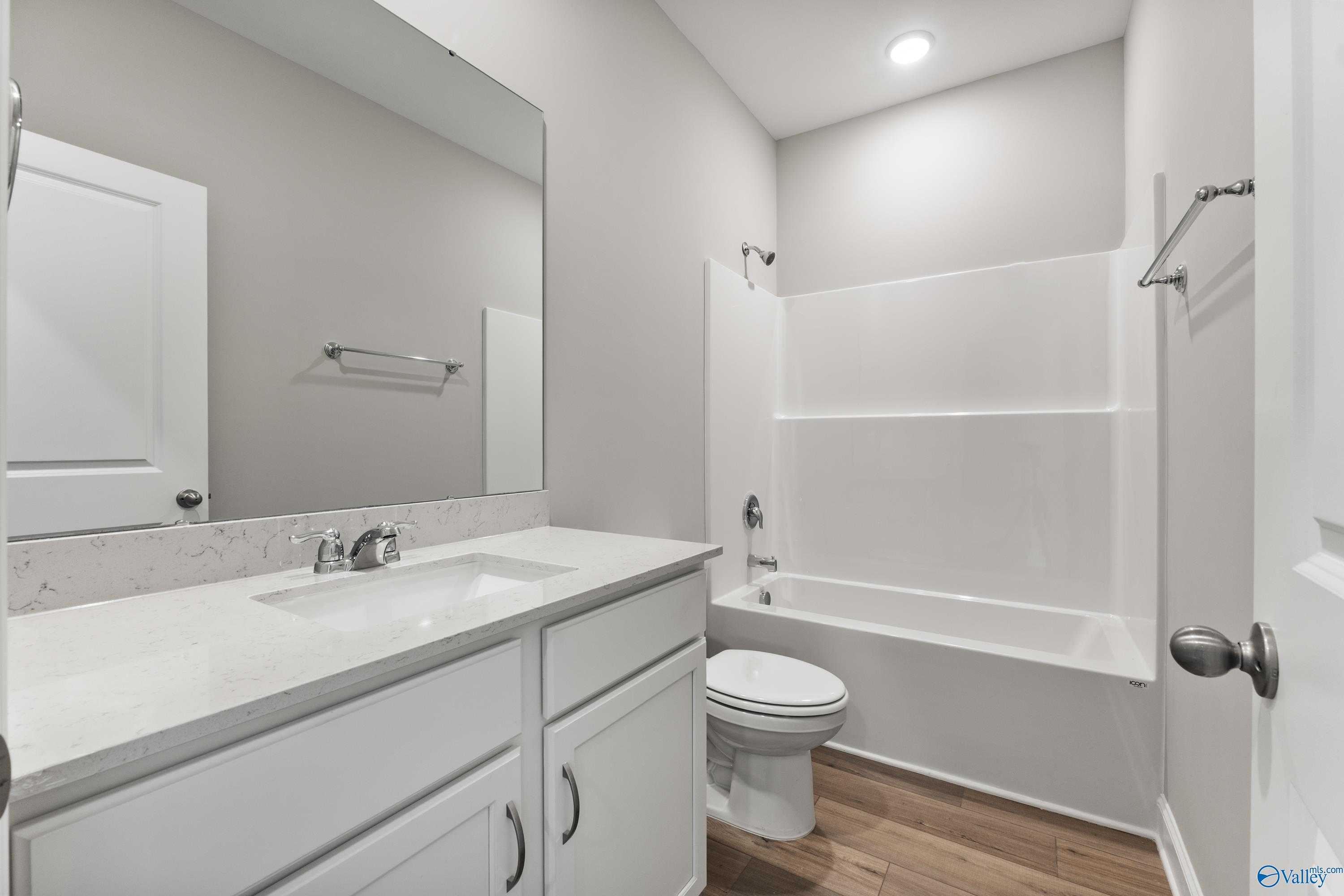 Modern secondary bathroom with white vanity, quartz countertop, tub-shower combo in Davidson Homes The Franklin, Huntsville AL