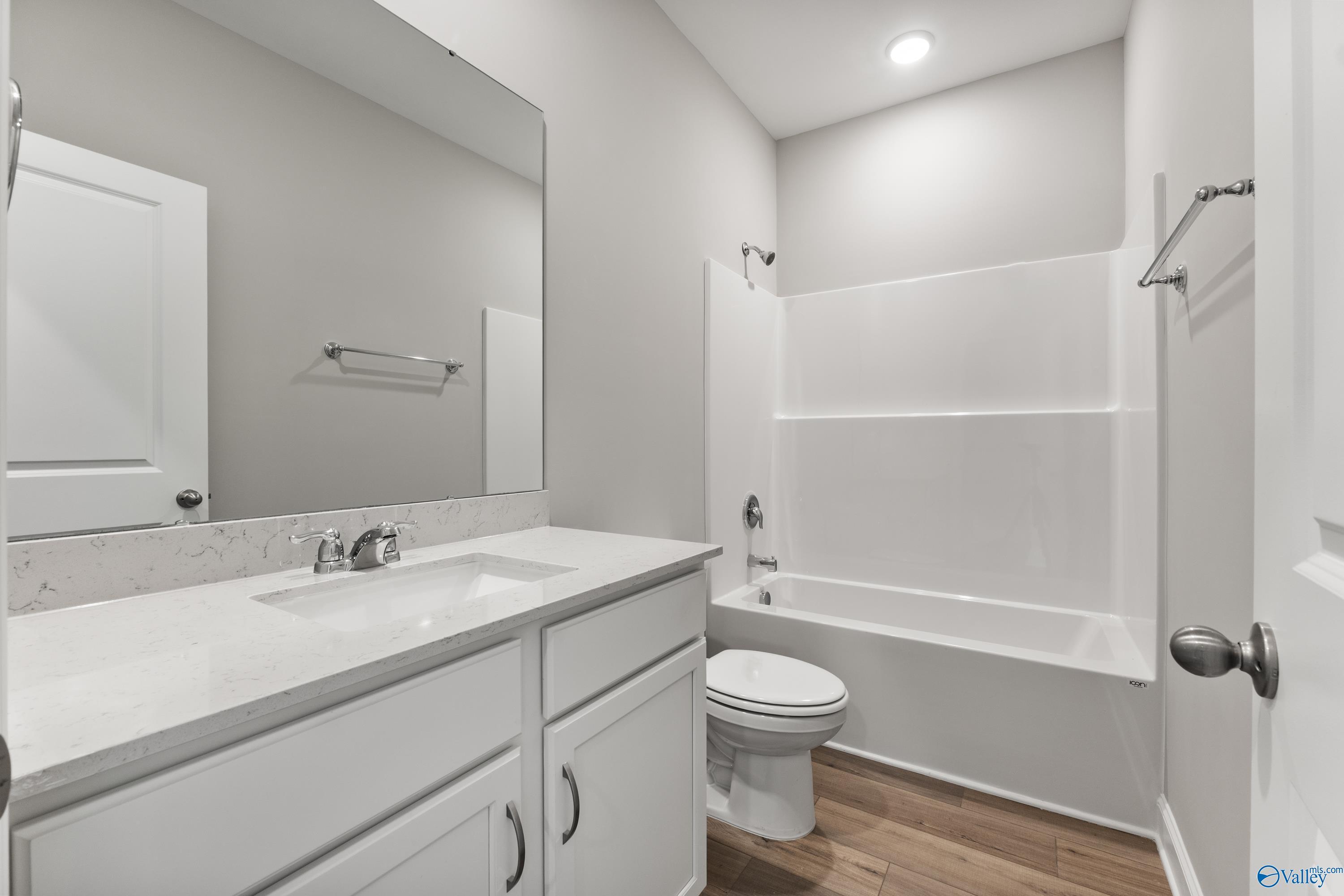 Modern secondary bathroom with white vanity, quartz countertop, tub-shower combo in Davidson Homes The Franklin, Huntsville AL