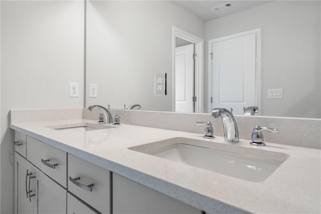 Elegant double vanity with quartz countertop, dual sinks, and chrome faucets in Davidson Homes The Cary A, Kennesaw, Georgia