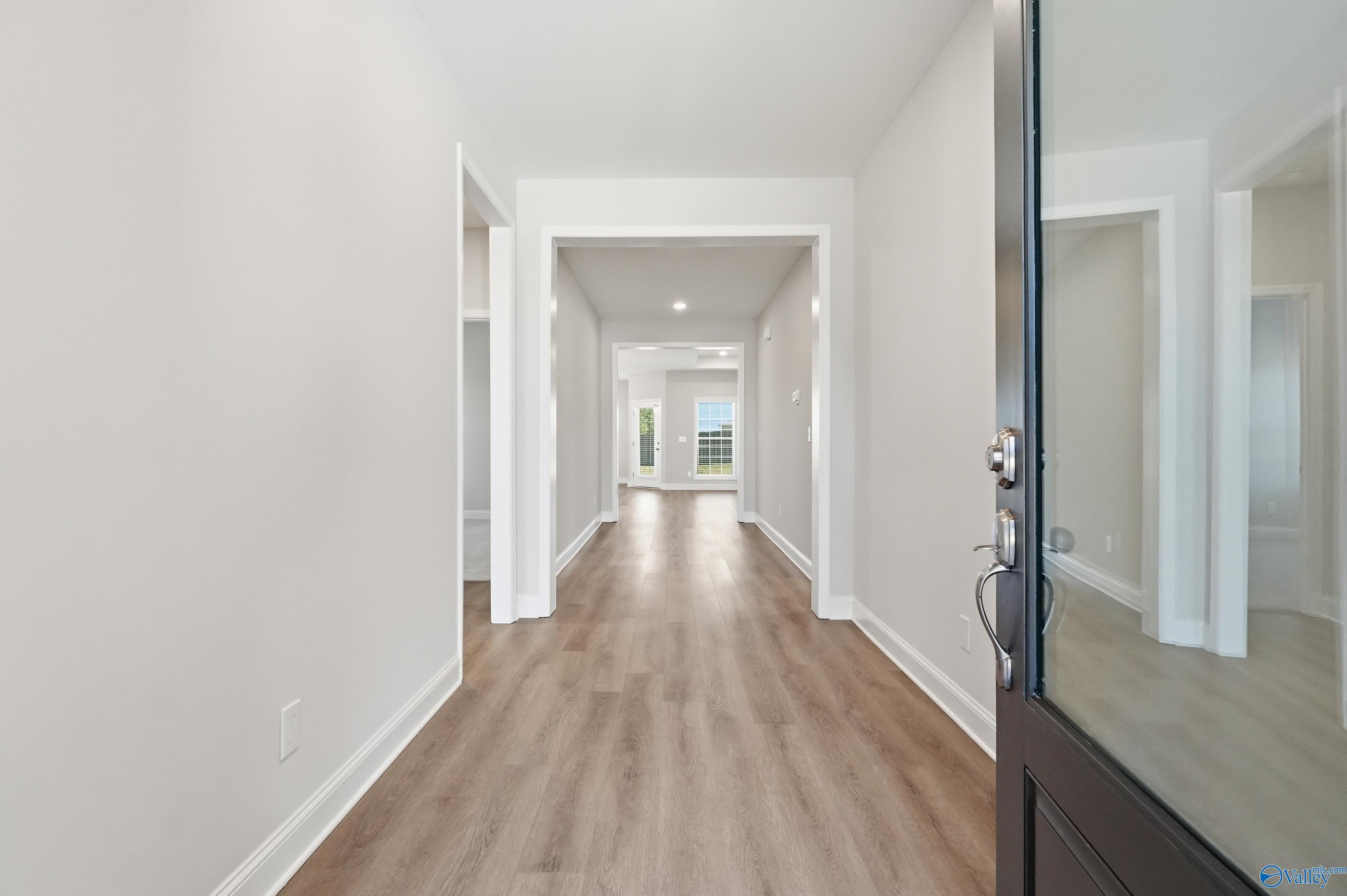 Bright, open foyer with luxury vinyl plank flooring and hallway view in The Harrison floor plan by Davidson Homes, Harvest.