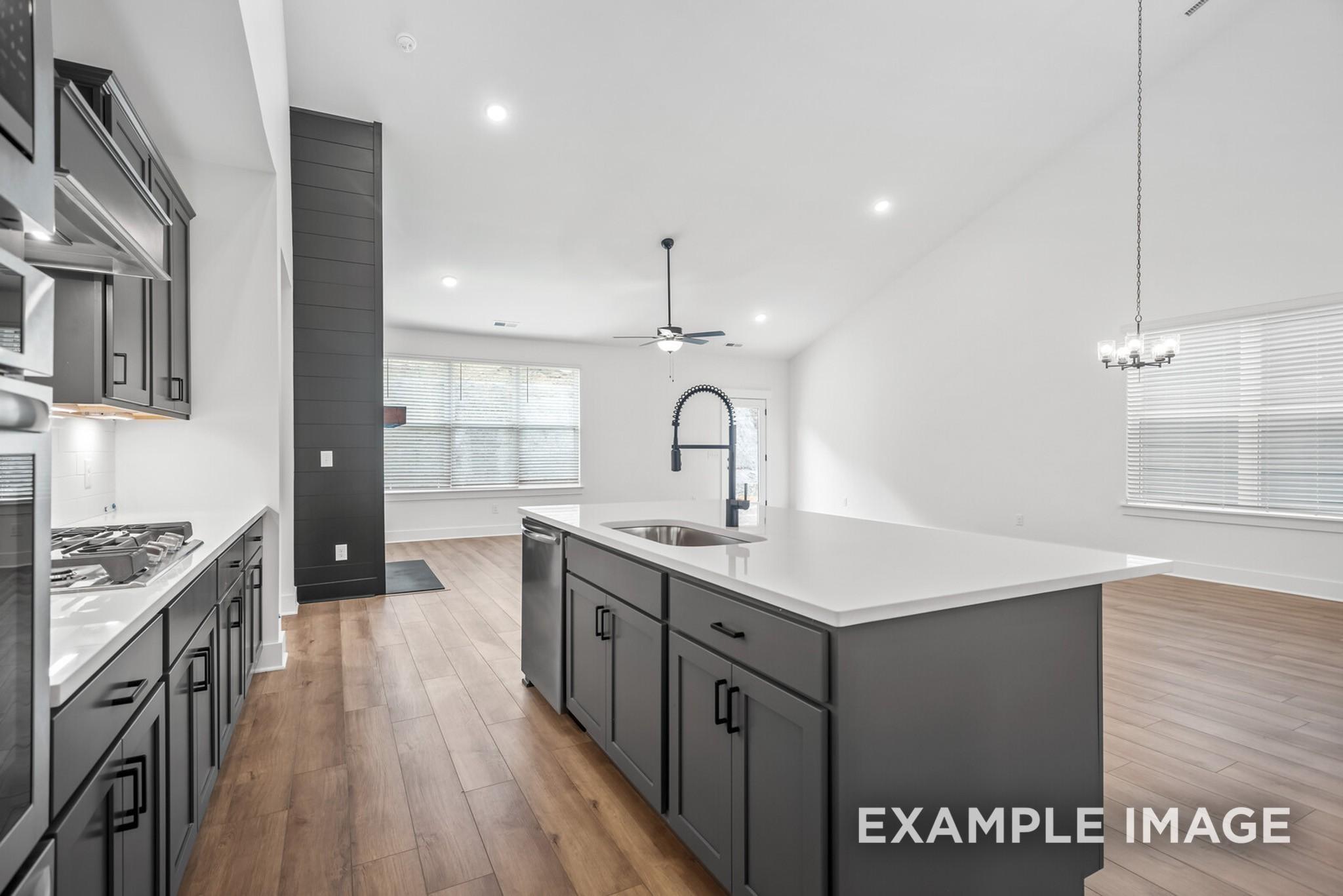 Modern open-concept kitchen with gray shaker cabinets, white quartz island, stainless appliances in Davidson Homes Ridgeport C, Gallatin, TN