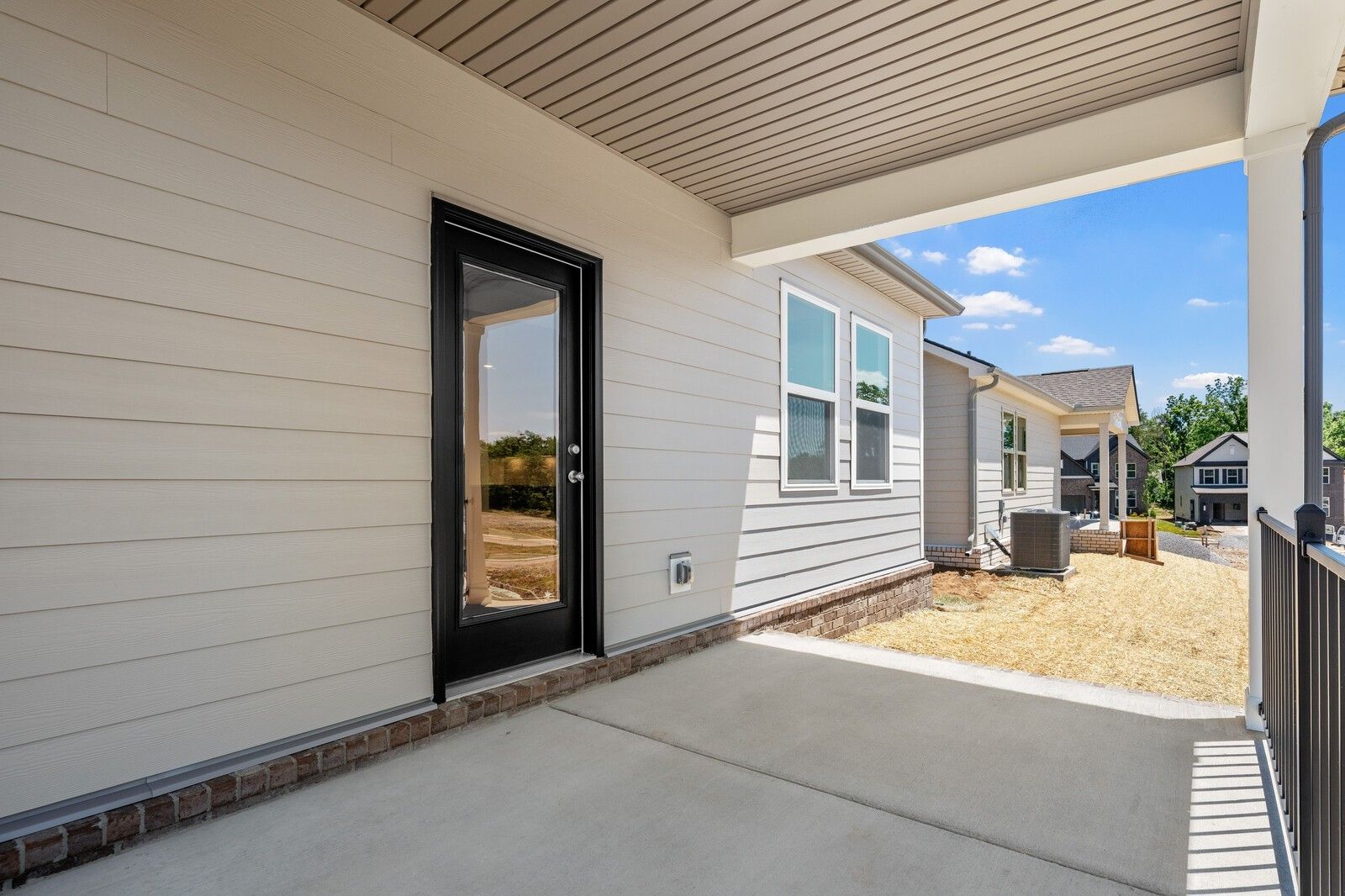 Covered patio and side exterior of The Cottonwood E floor plan at Woods Crossing in Gallatin, Tennessee.