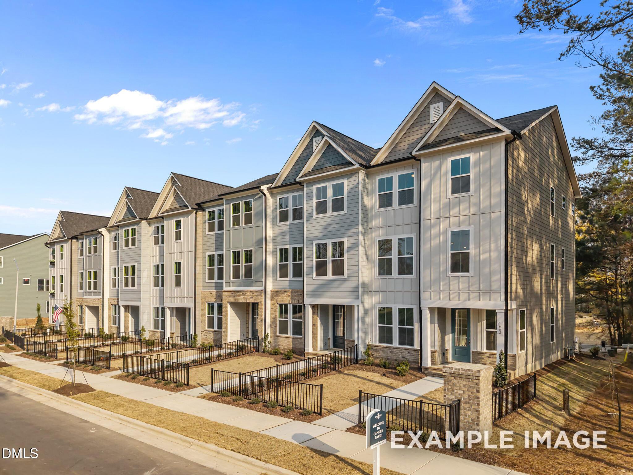 Modern 3-story townhomes with gray siding, gabled roofs, and front stoops in Camden Park, Knightdale, North Carolina by Davidson Homes