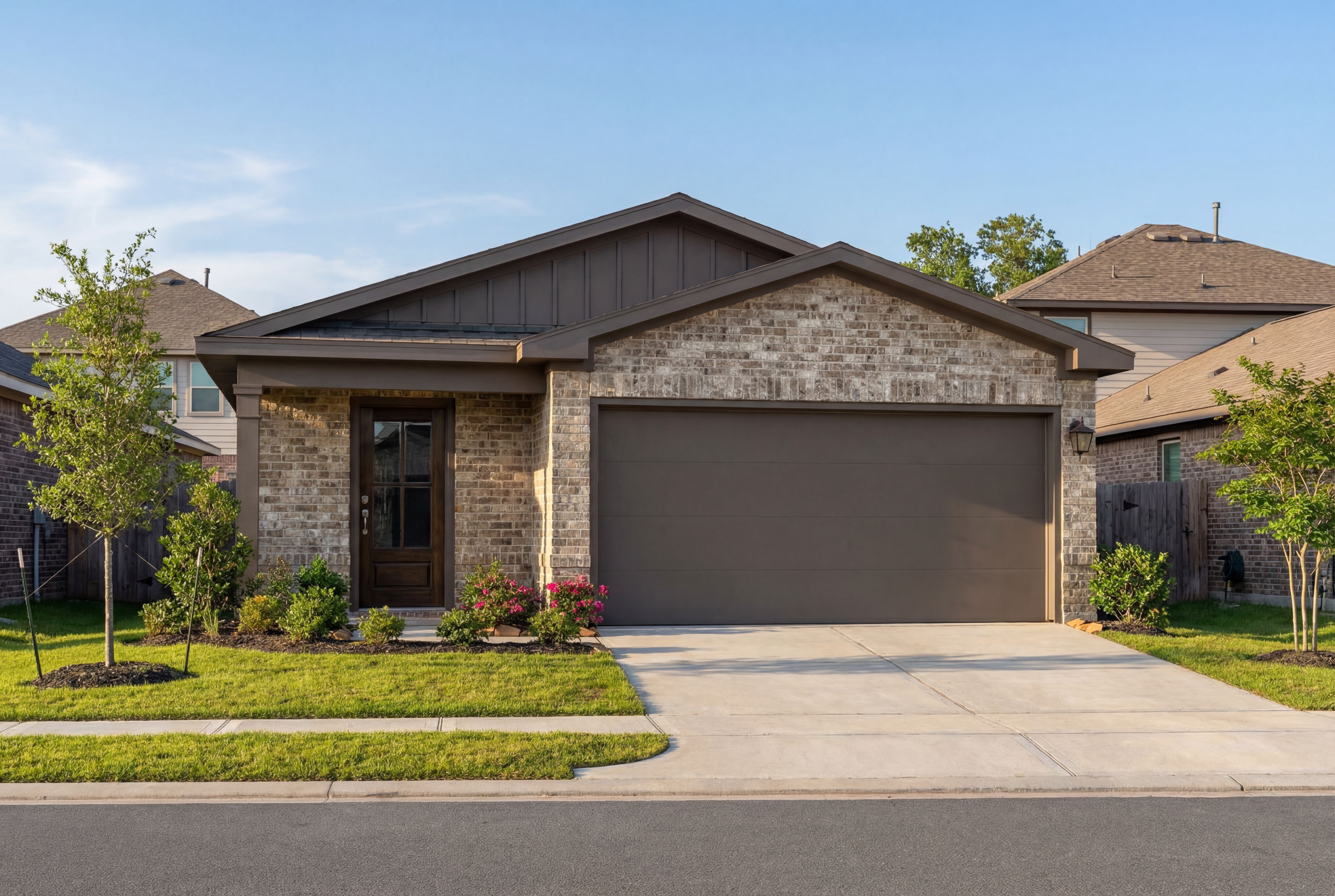 Contemporary brick and siding facade of The Frio F 1-story home by Davidson Homes, 2-car garage, landscaped yard in Heartland Texas