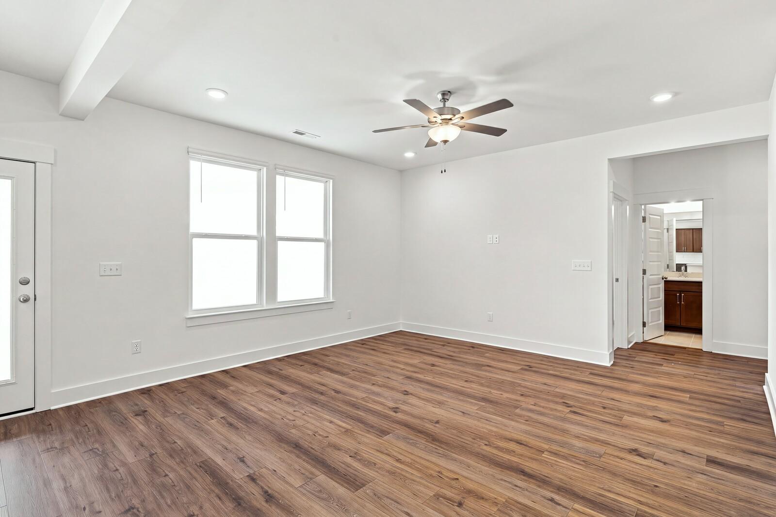 Bright flex room with wood-look flooring, ceiling fan, and double windows in Davidson Homes The Willow C, Gallatin, TN