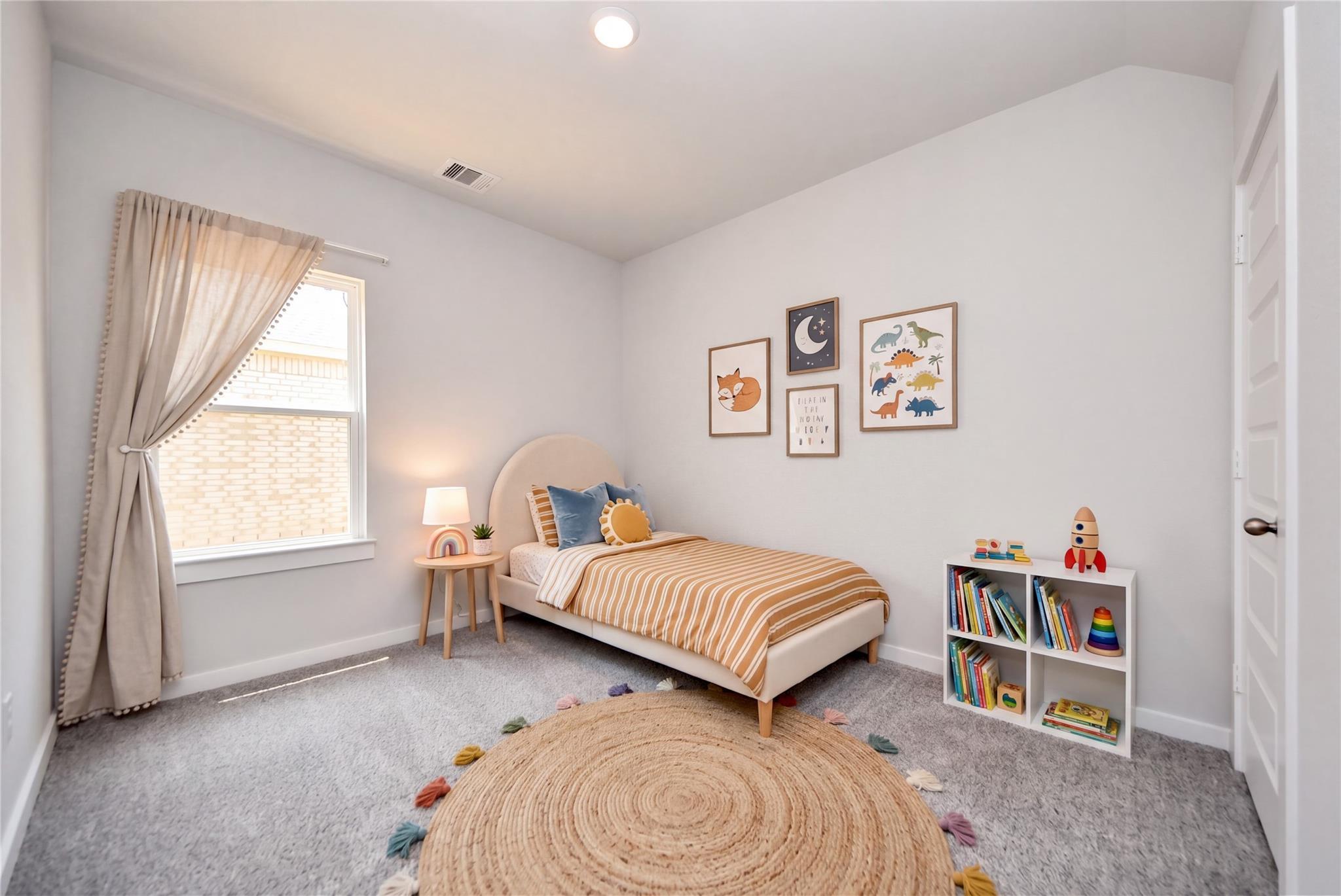 Cozy children's bedroom with platform bed, tassel rug, and bookshelf in The Sabine E floor plan at Windmill Estates, Texas.