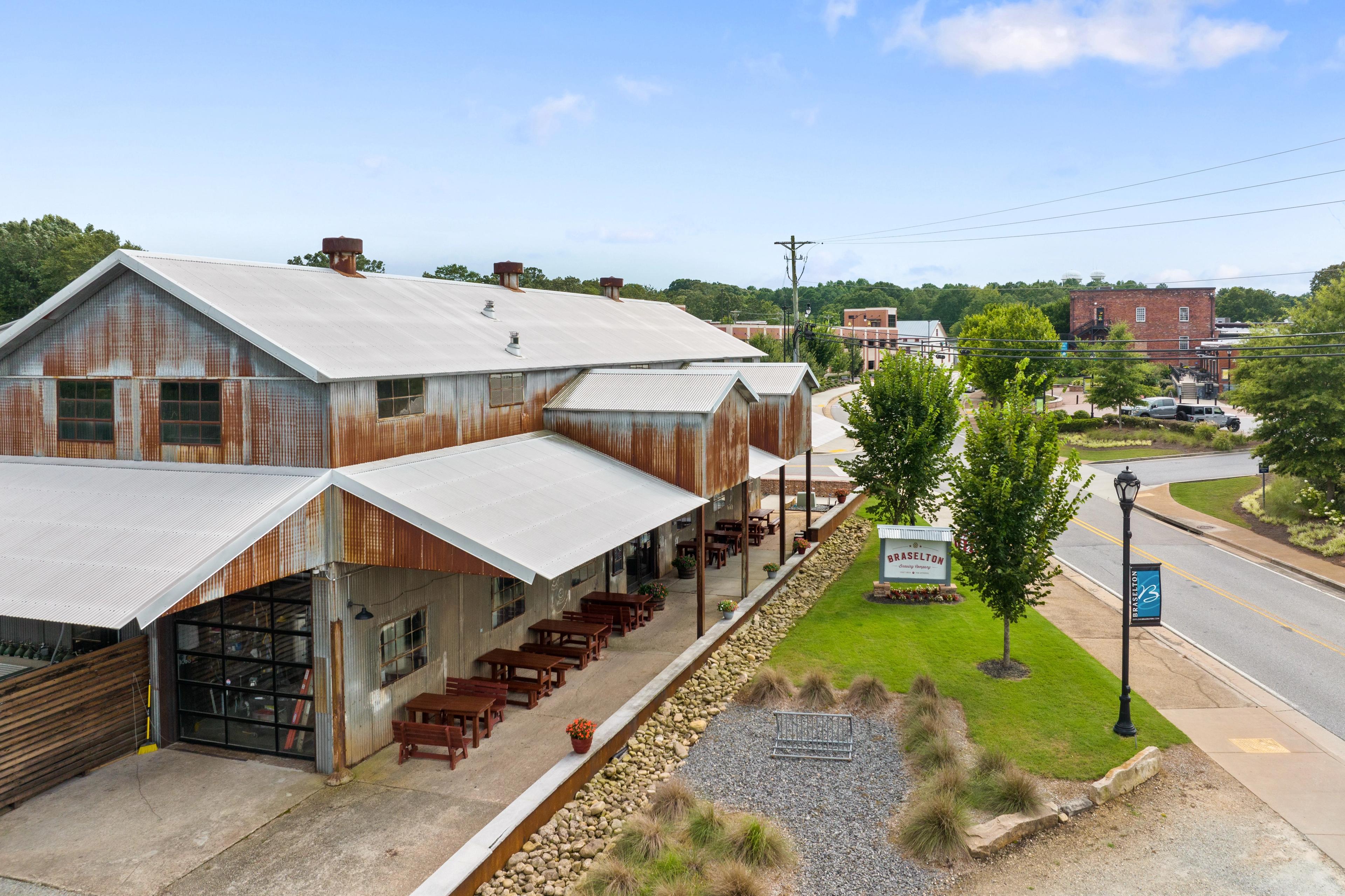 Rustic barn-style pavilion at Wehunt Meadows in Hoschton Georgia with outdoor seating and metal roof