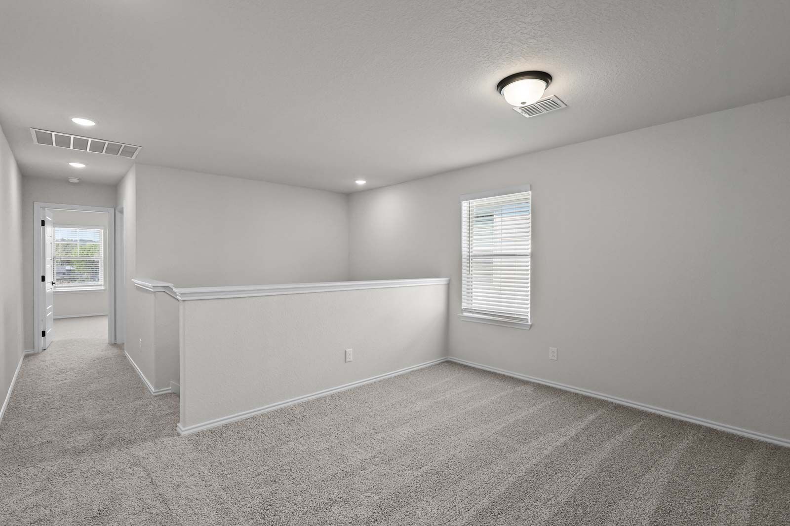 Spacious upstairs loft area in The Florence B home design featuring neutral carpet and abundant natural light.
