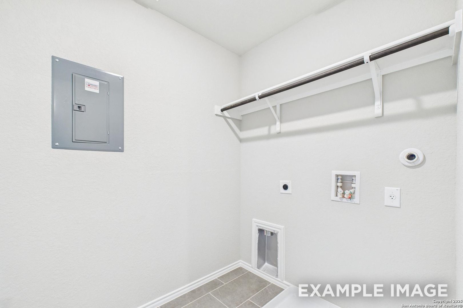 Bright laundry room with utility sink, white shelving, pet door, and electrical panel in Davidson Homes The Charlotte A, San Antonio