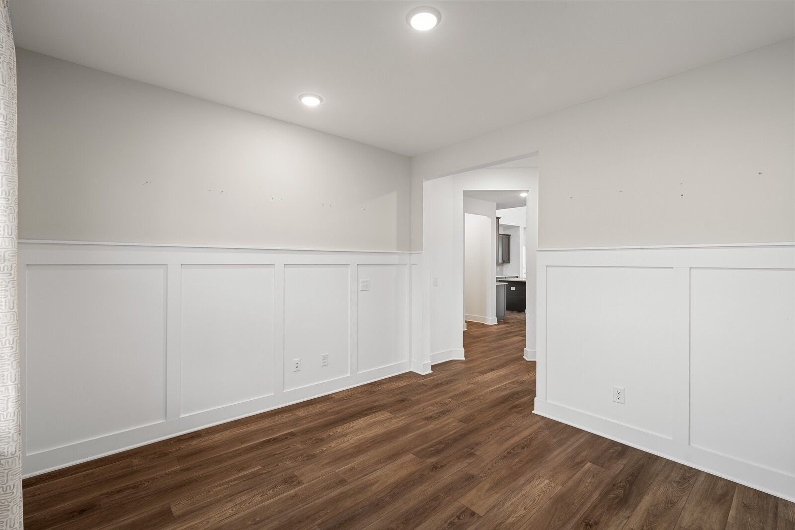 Bright bedroom with white wainscoting, beige walls, hardwood floors, and en-suite bathroom in Davidson Homes The Ridgeport, Gallatin, TN