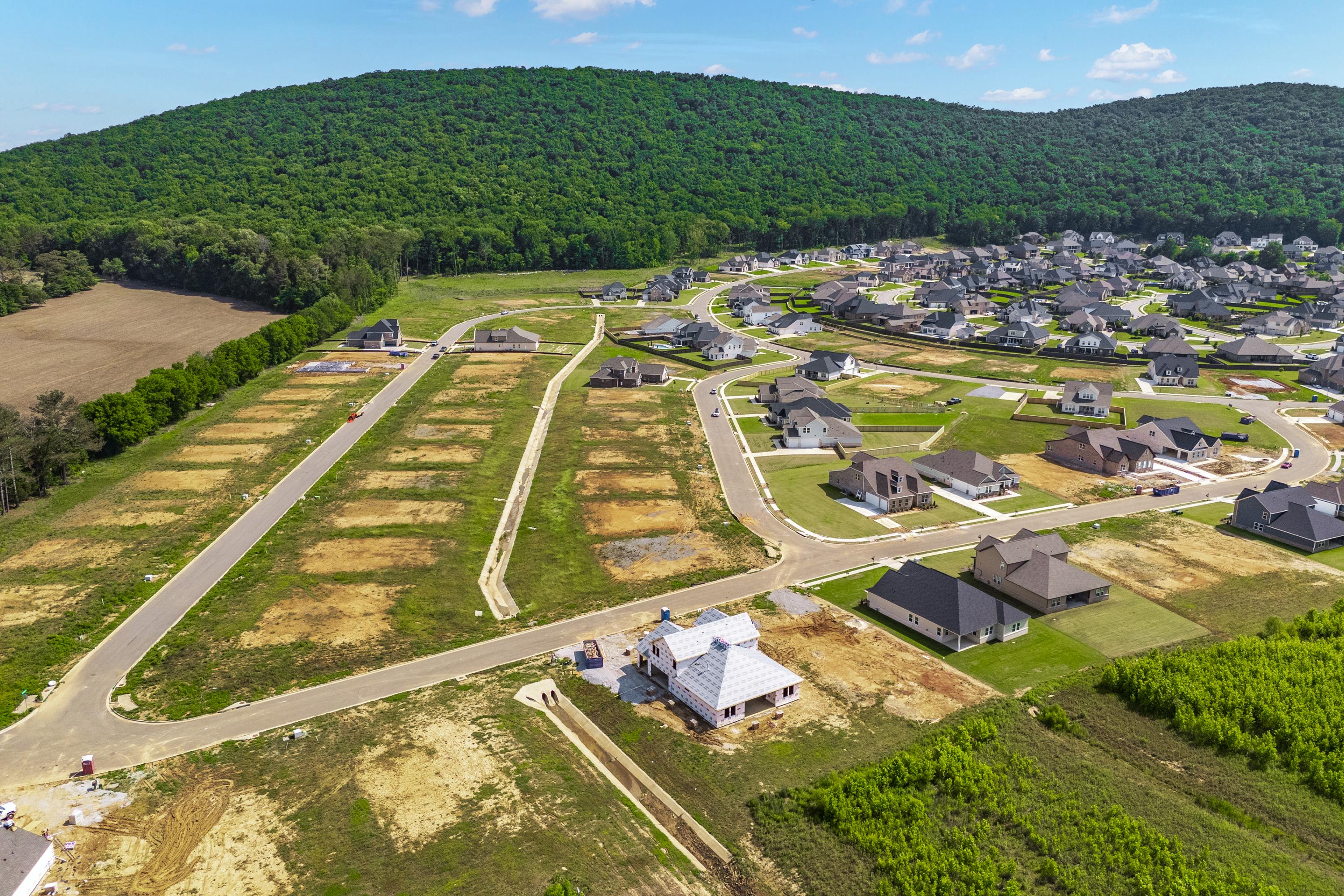 Aerial view of new homes and lots at The Meadows at Hampton Cove in Owens Cross Roads AL amid green hills and forests