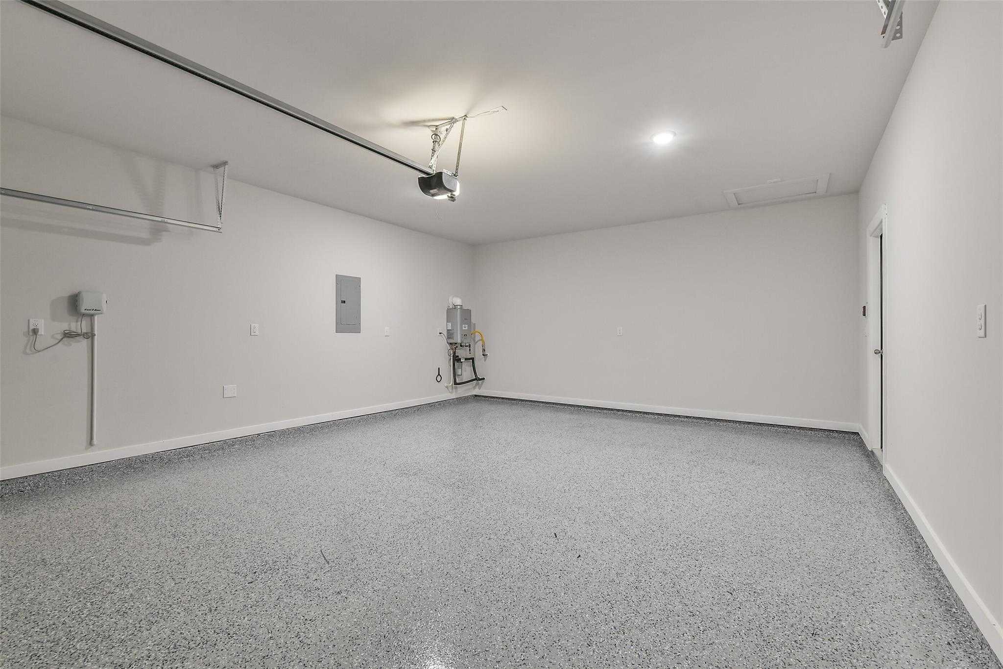 Spacious 2-car garage with epoxy flooring, utility sink, and storage in Davidson Homes The Rio Grande H, Magnolia, Texas