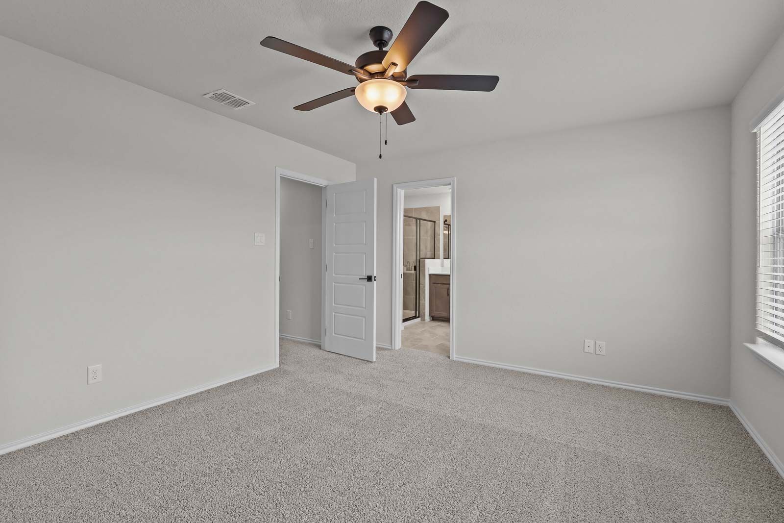 Spacious upper-floor master bedroom in The Florence B by Davidson Homes, featuring neutral carpet and an en-suite bathroom.