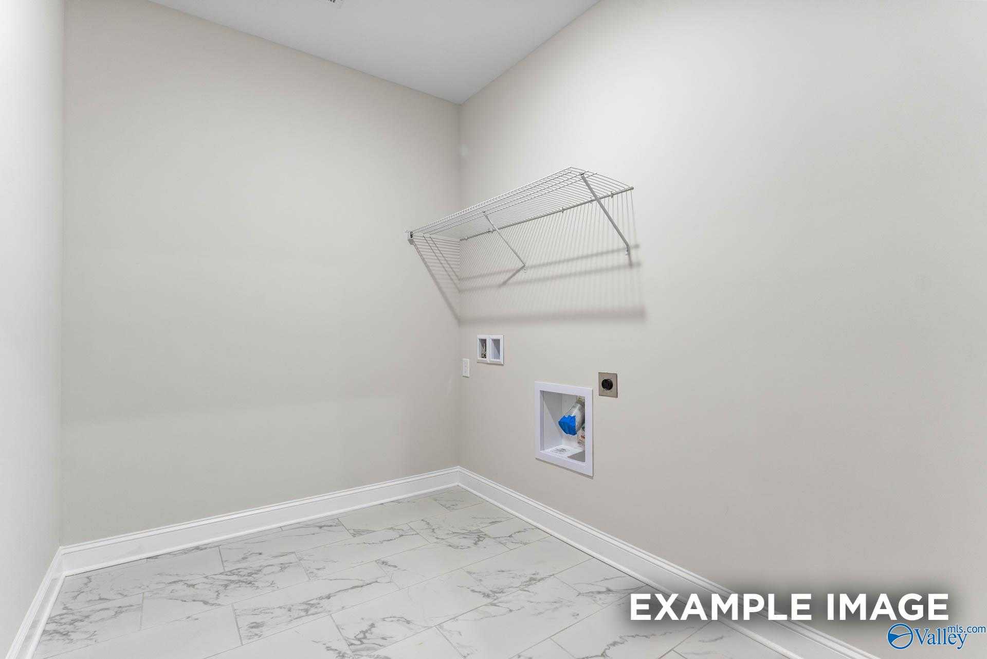 Spacious laundry room with wire shelving, washer-dryer hookups, and tile flooring in Davidson Homes The Finleigh, Briercreek, Meridianville, Alabama