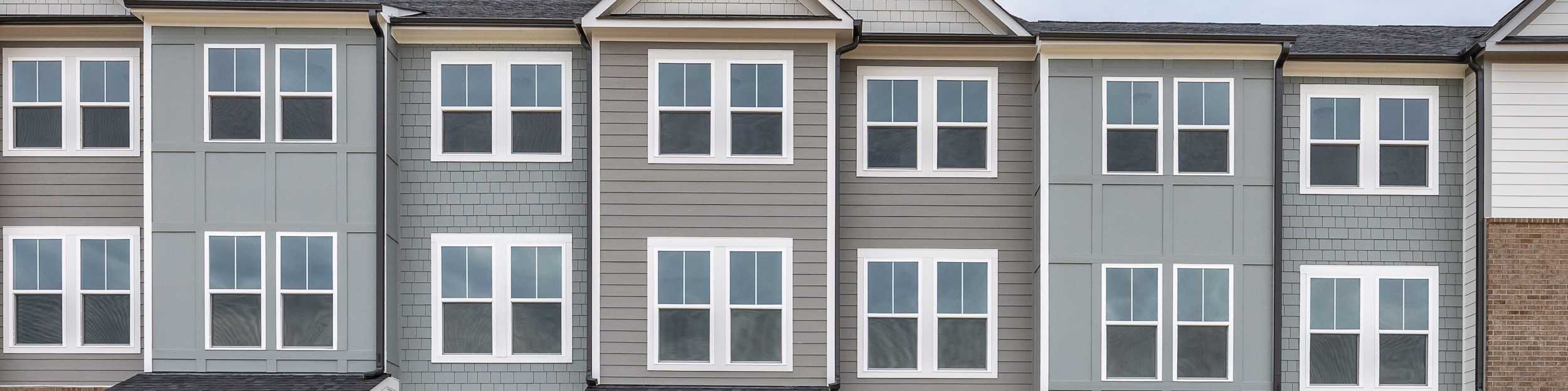 Three-story townhomes at Summers Walk in Davidson, NC, featuring modern brick and siding exteriors by Davidson Homes.