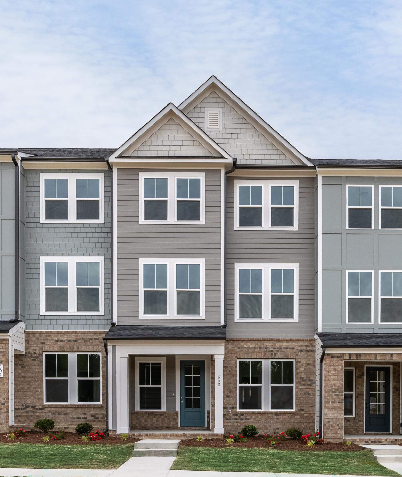 Three-story townhomes at Summers Walk in Davidson, NC, featuring modern brick and siding exteriors by Davidson Homes.