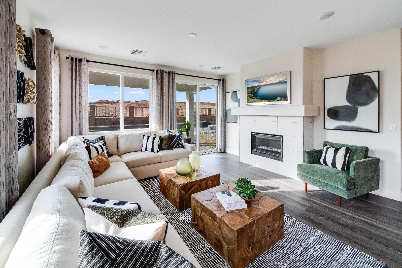 Spacious living room in South Ranch Western Collection, Prescott AZ featuring white sectional sofa, gas fireplace, and large sliding windows