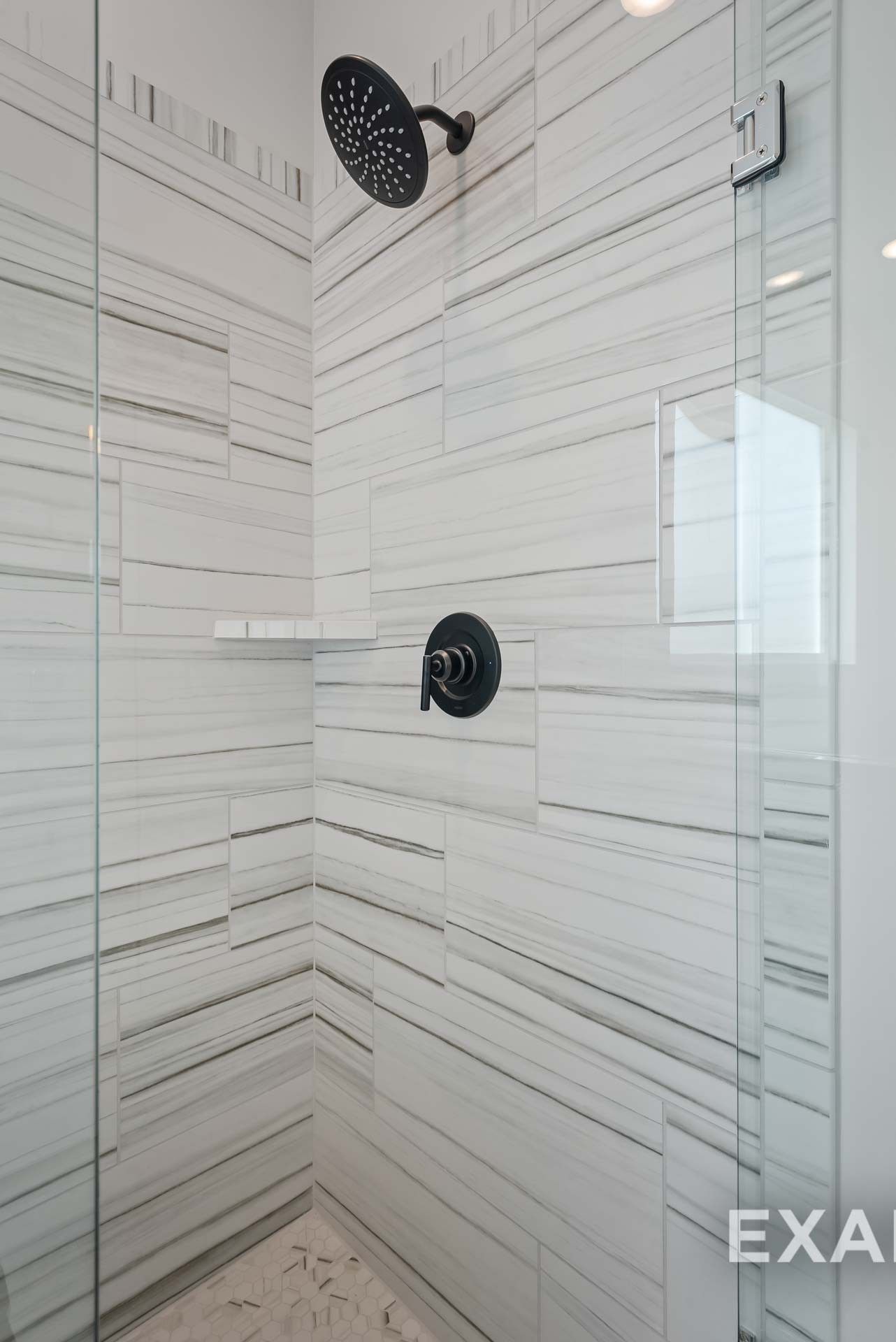 Modern frameless glass shower with white subway tiles, black rainfall showerhead in Davidson Homes The Ridgeport C, Gallatin, TN