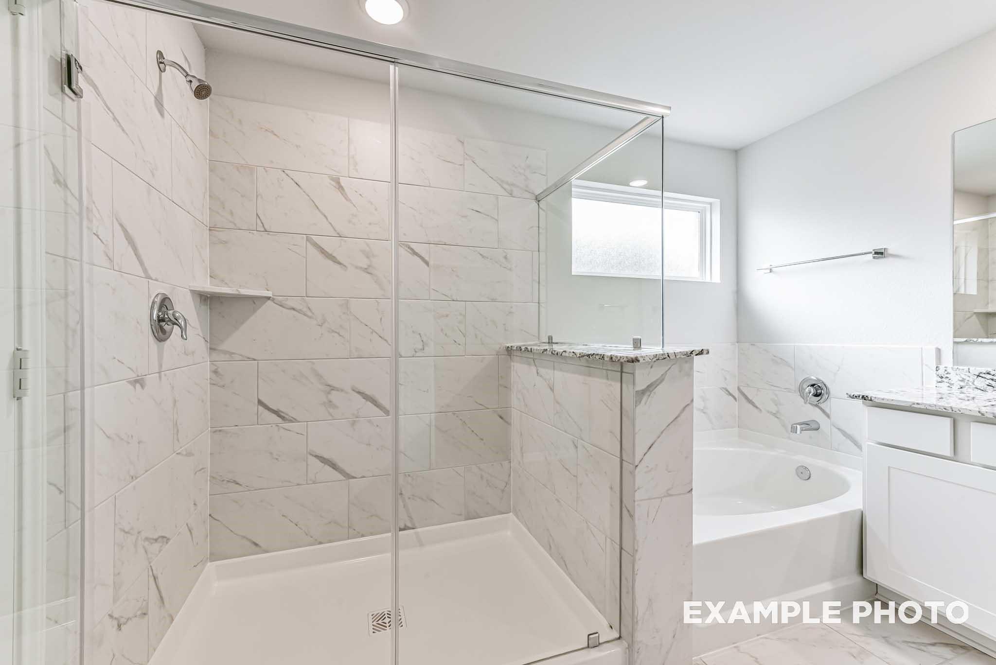 Modern master bath with frameless glass shower, freestanding tub, and quartz double vanity in Davidson Homes The Riviera A, Rosharon, Texas