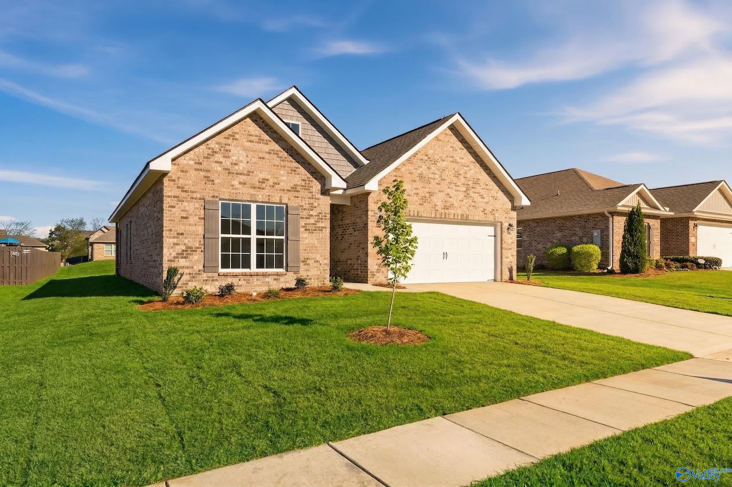 Single-story brick home with 2-car garage, manicured lawn, and driveway in Flint Meadows, New Market, Alabama by Davidson Homes