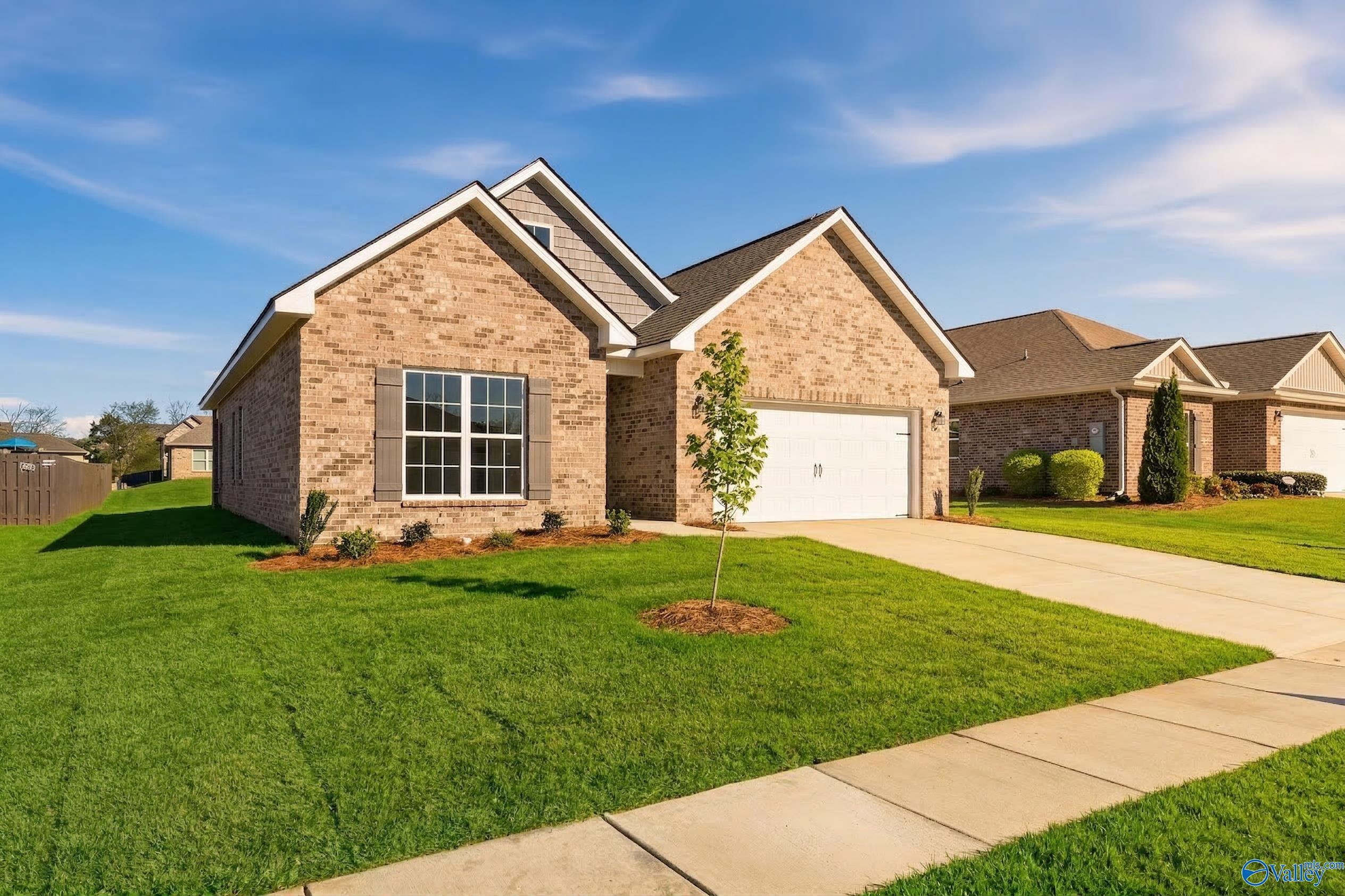 Single-story brick home with 2-car garage, manicured lawn, and driveway in Flint Meadows, New Market, Alabama by Davidson Homes