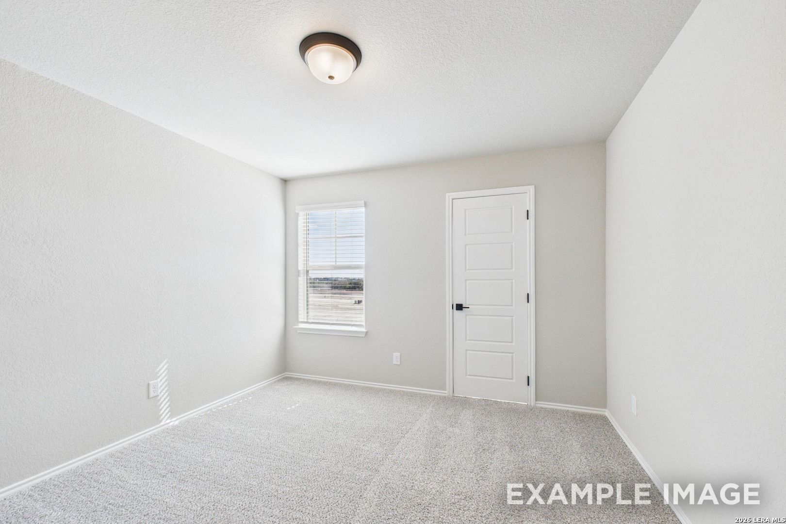 Bright, carpeted bedroom with neutral walls in The Charlotte B floor plan by Davidson Homes in Cedar Heights, San Antonio.