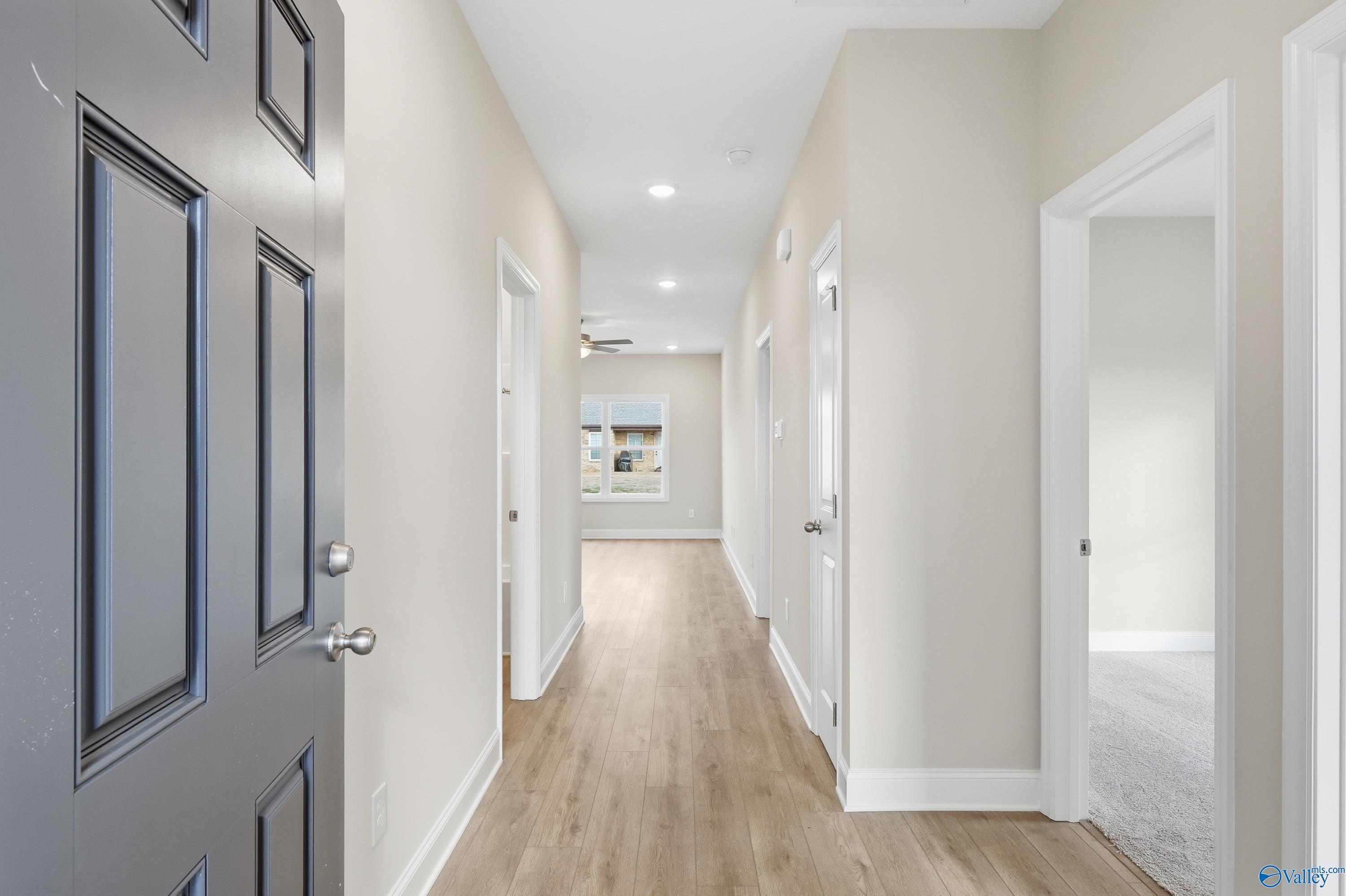 Bright hallway with beige walls, hardwood floors, and recessed lighting in Davidson Homes The Butler, Toney, Alabama