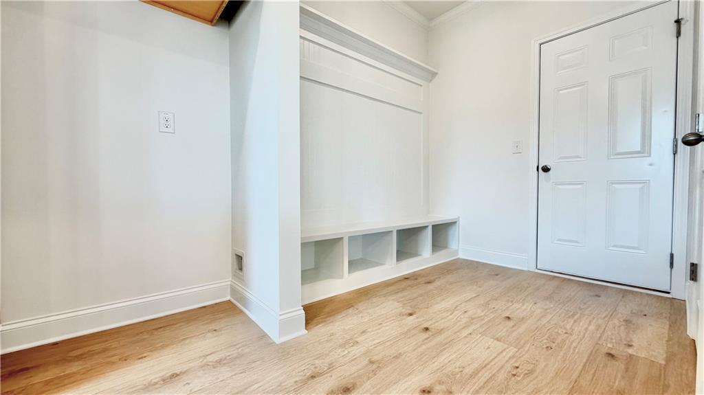 Mudroom with built-in bench storage and hardwood flooring in The Hickory C floor plan at Wehunt Meadows, Hoschton, GA.