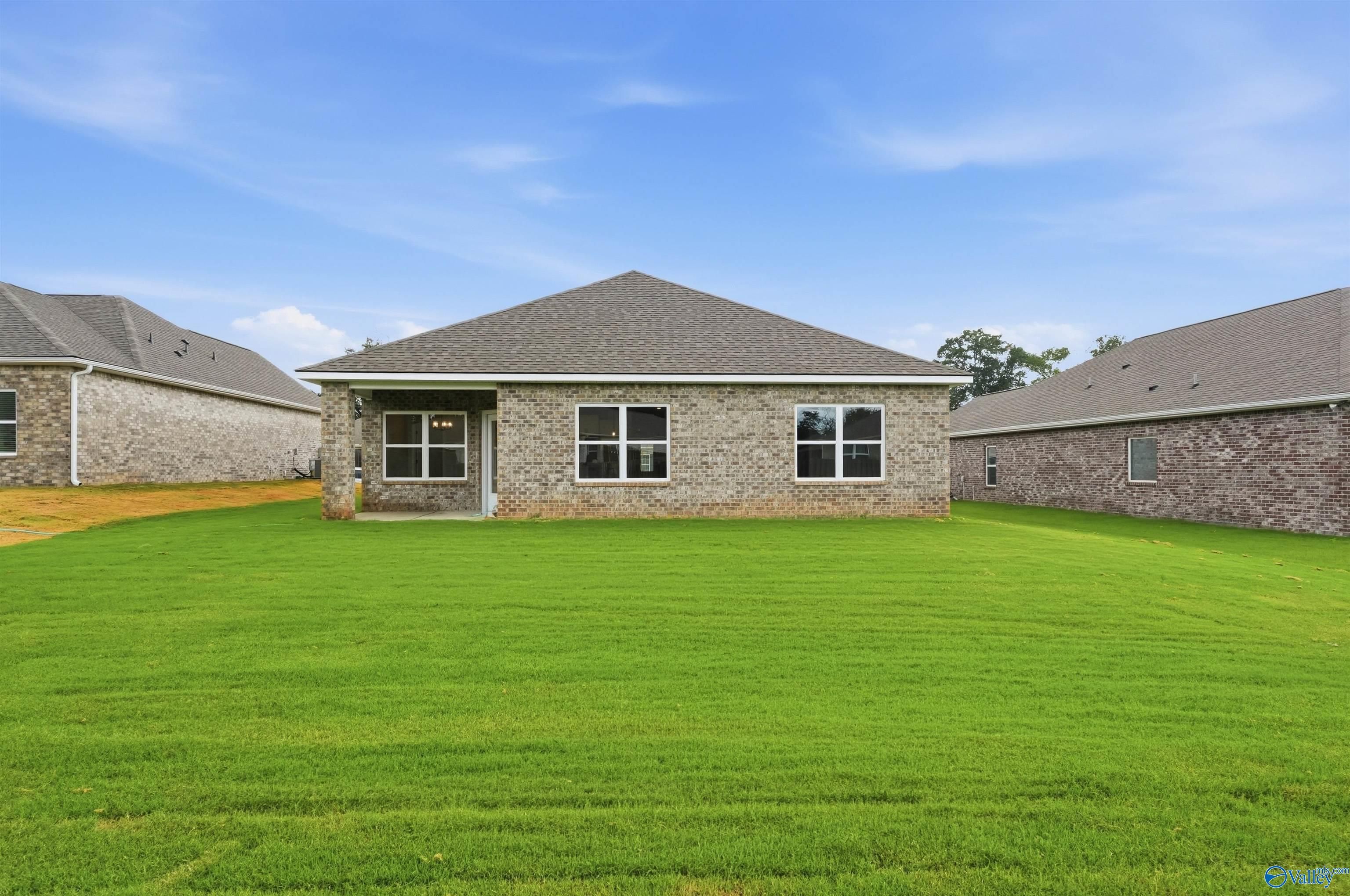 Back exterior view of Daphne C floor plan with covered patio and spacious backyard in Flint Meadows, New Market, Alabama.