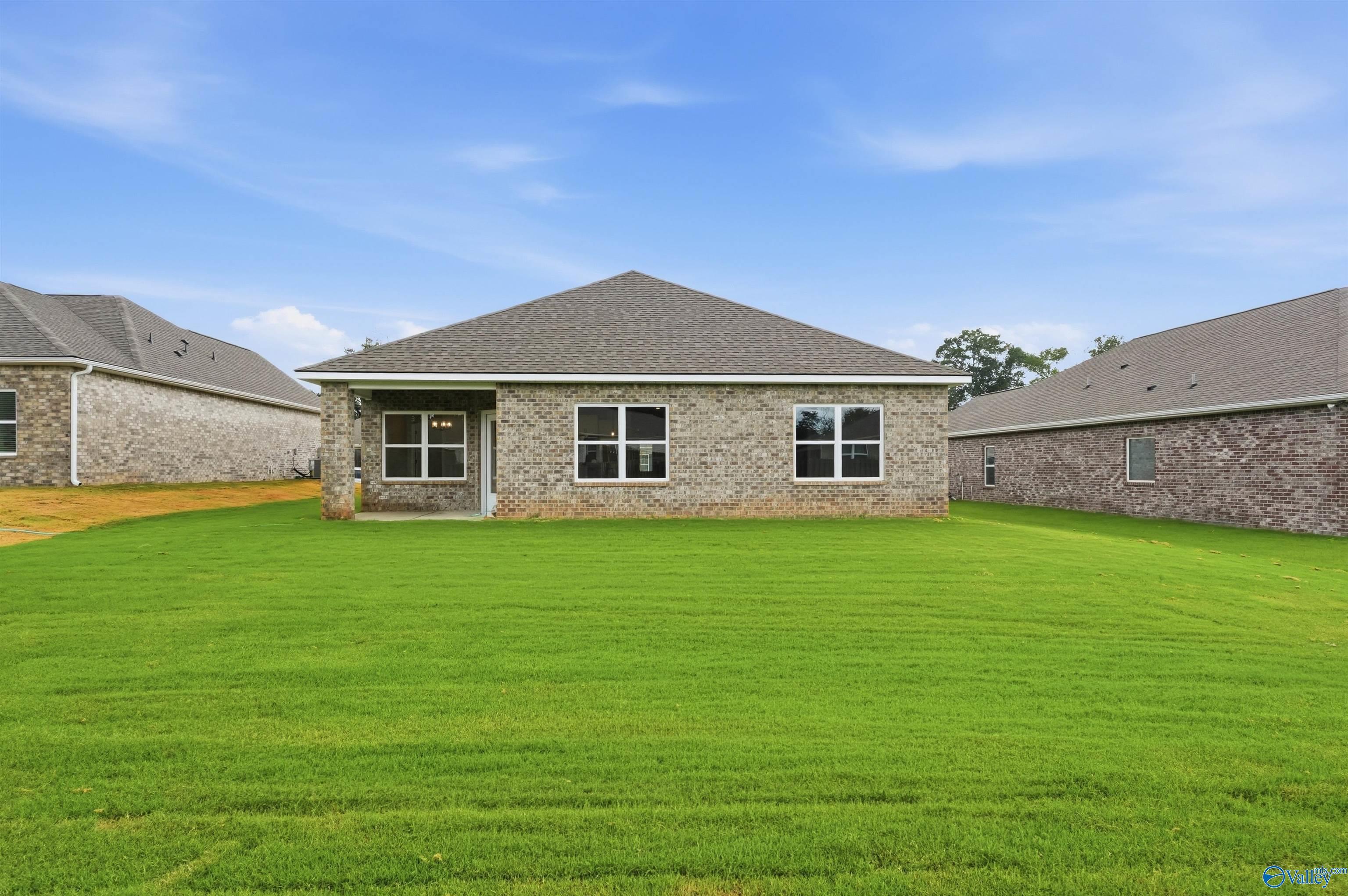 Back exterior view of Daphne C floor plan with covered patio and spacious backyard in Flint Meadows, New Market, Alabama.