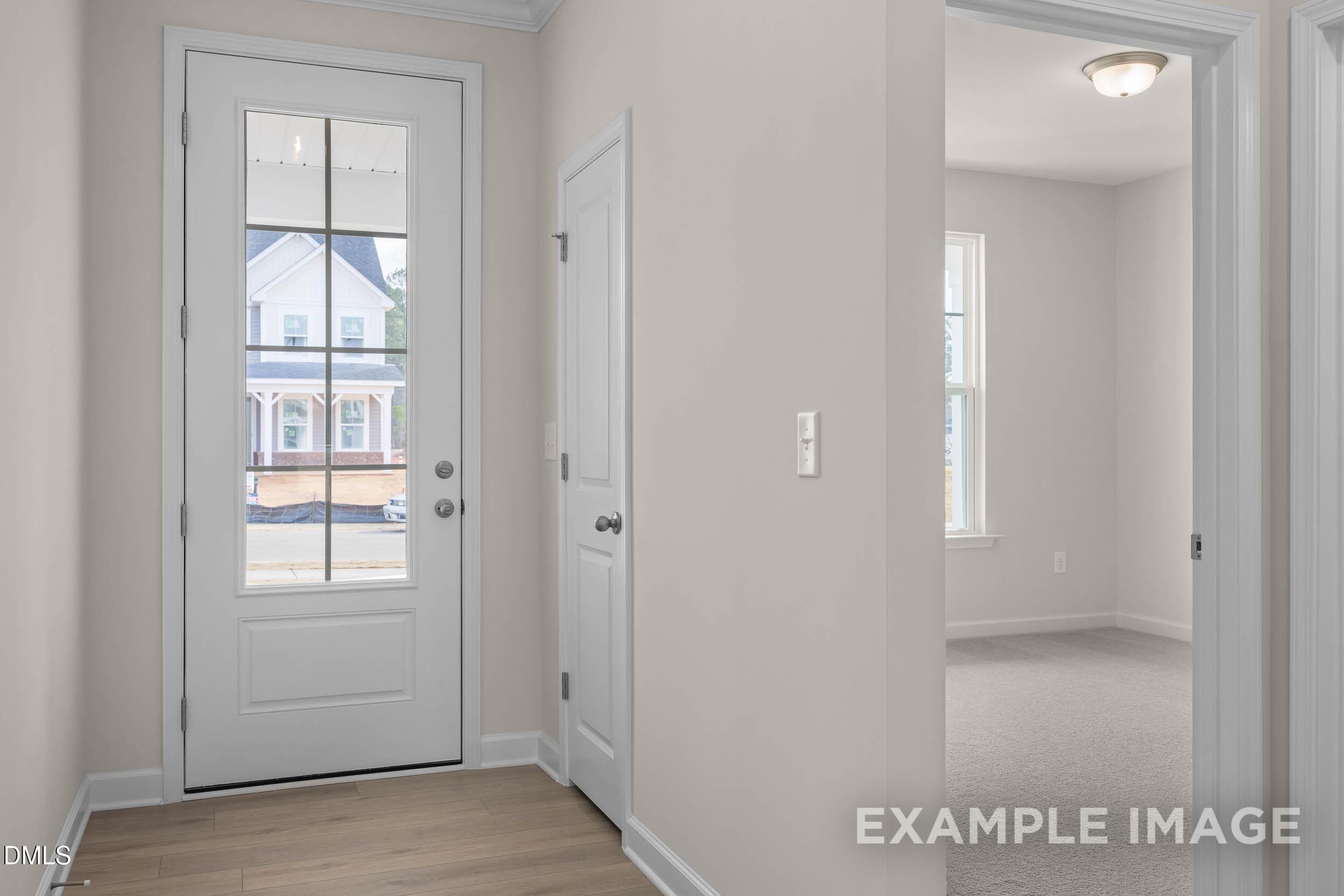 Bright entryway with glass-paneled front door and closet in The Franklin C floor plan at Retreat at North Main, Lillington.