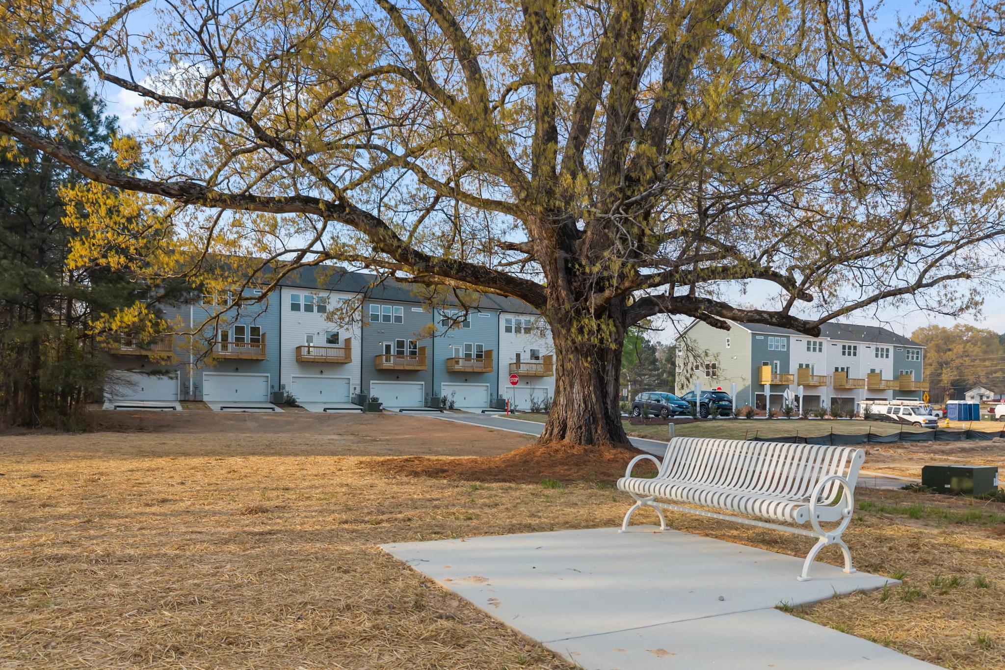 White bench overlooking The Mitchell 3-story multi-family homes by Davidson Homes in Knightdale, North Carolina.