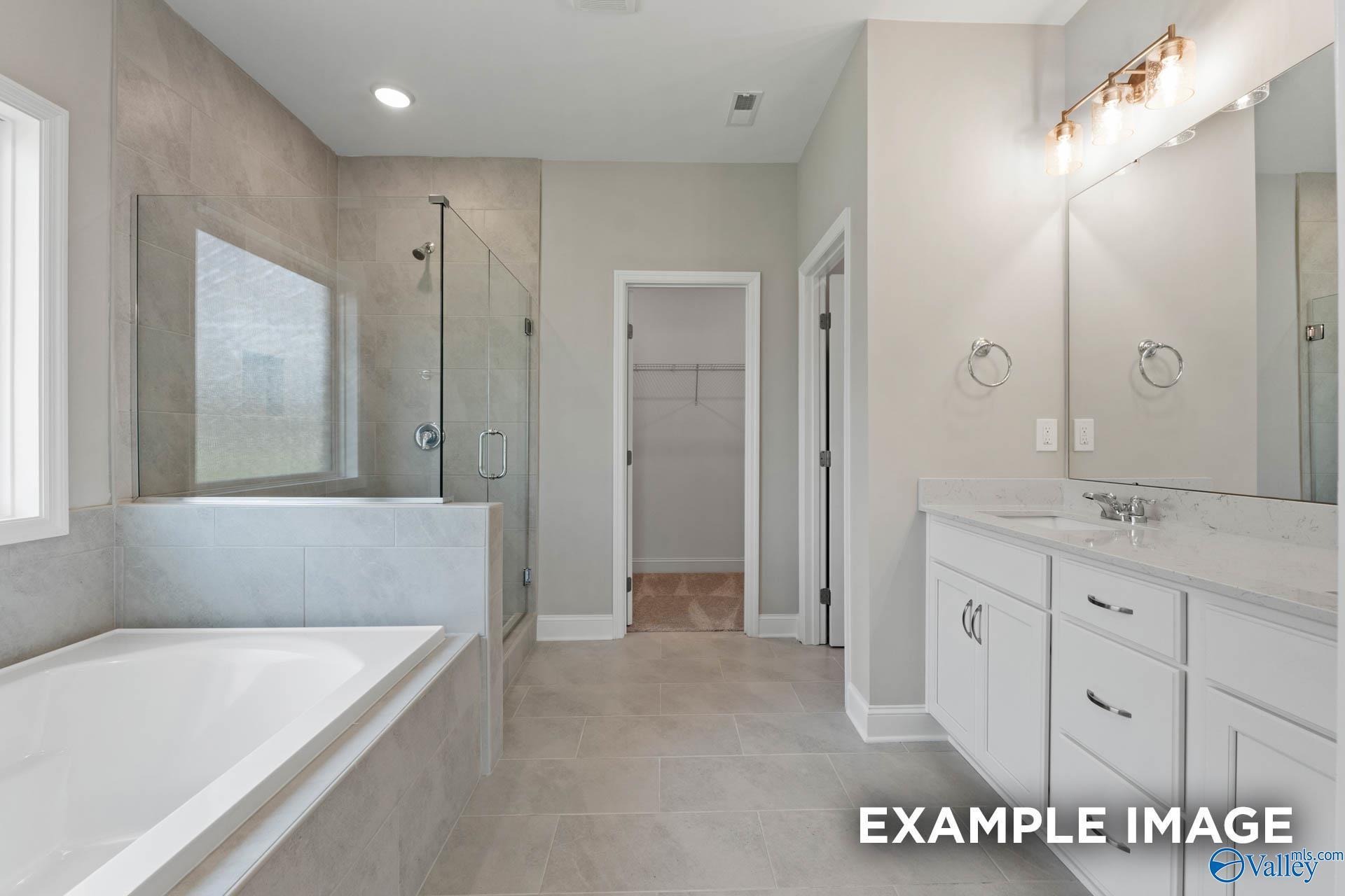Modern master bathroom featuring freestanding tub, glass shower, double vanity in Davidson Homes The Montgomery B, Hartselle, Alabama