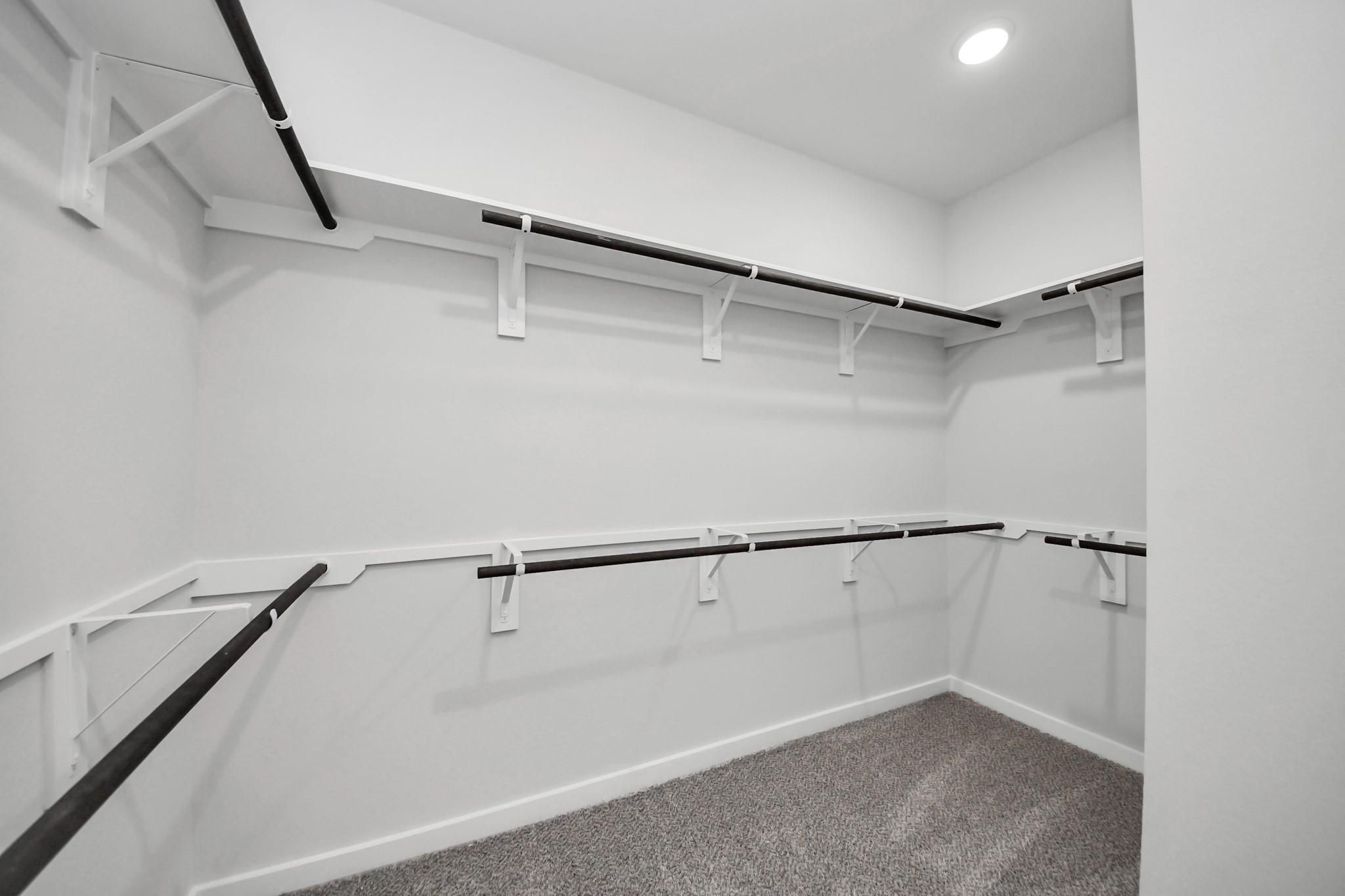 Spacious walk-in closet with custom shelving in The Riviera C floor plan at River Ranch Meadows, Dayton, Texas.