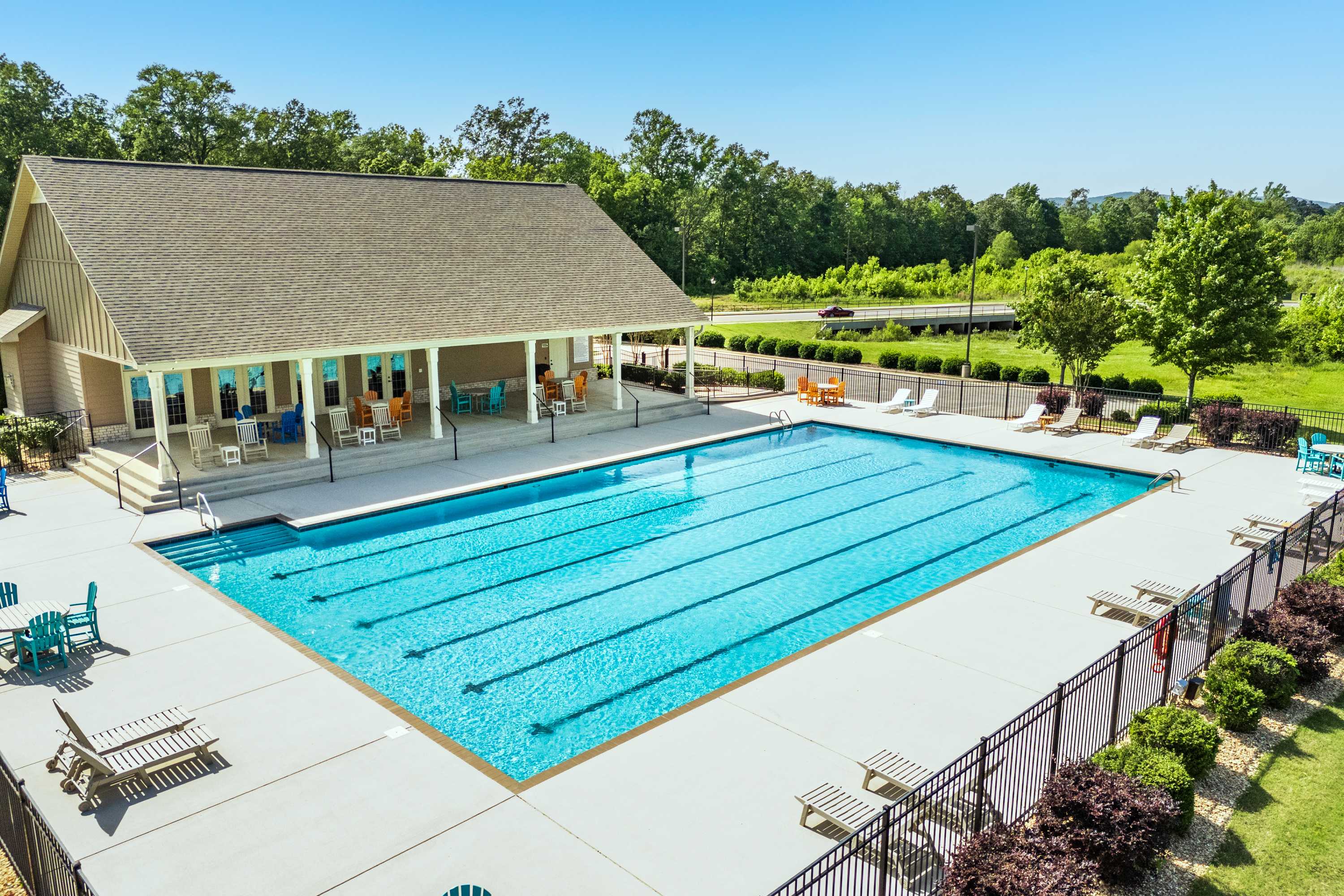 Resort-style lap pool at The Meadows at Hampton Cove in Owens Cross Roads Alabama with lounge chairs, umbrellas and covered clubhouse