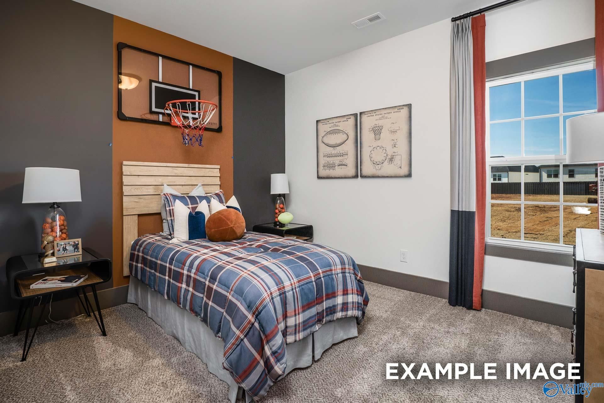 Boy's bedroom with basketball hoop, plaid bedding, orange accents, and sports art in Davidson Homes The Rockford B, Madison, Alabama